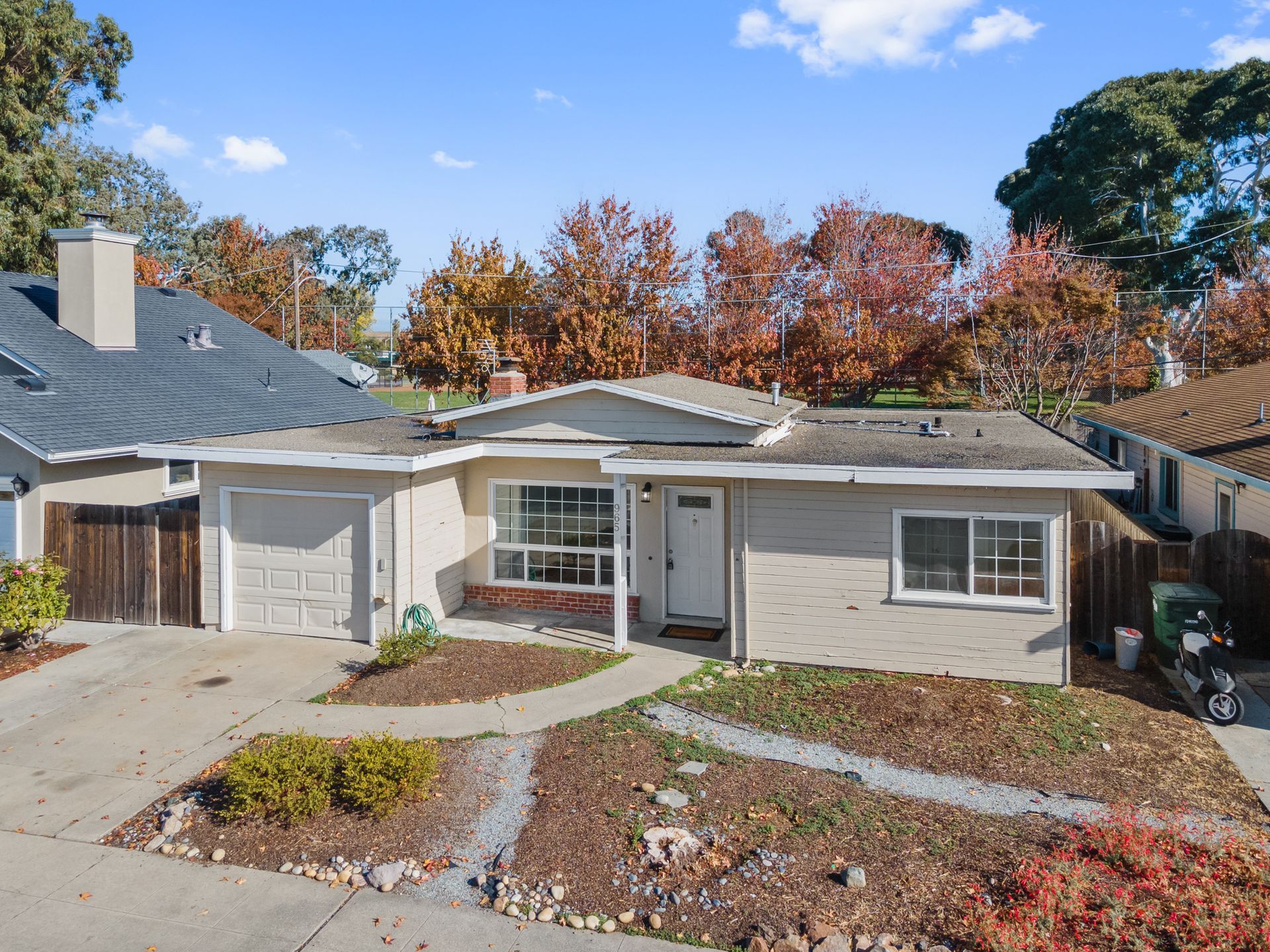 An aerial view of a house with trees in the background