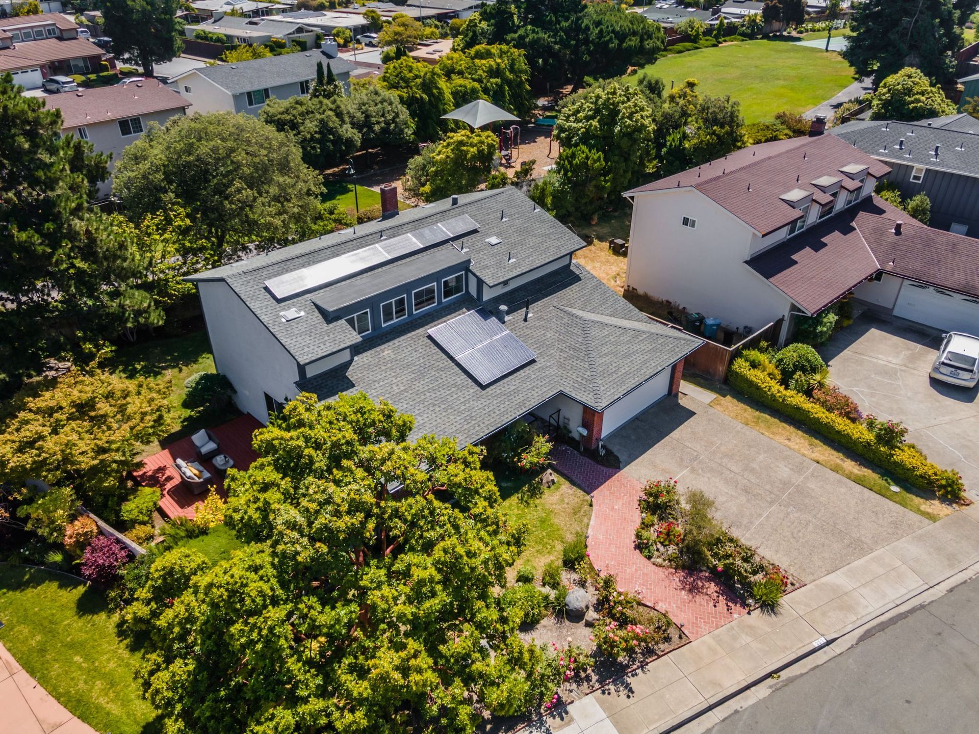 An aerial view of a house with solar panels on the roof