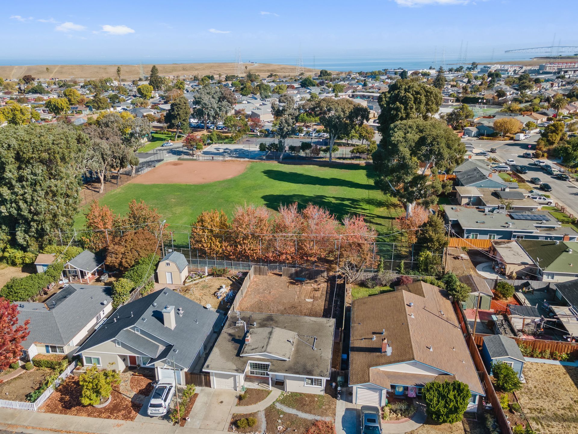 An aerial view of a residential area with houses and a baseball field.