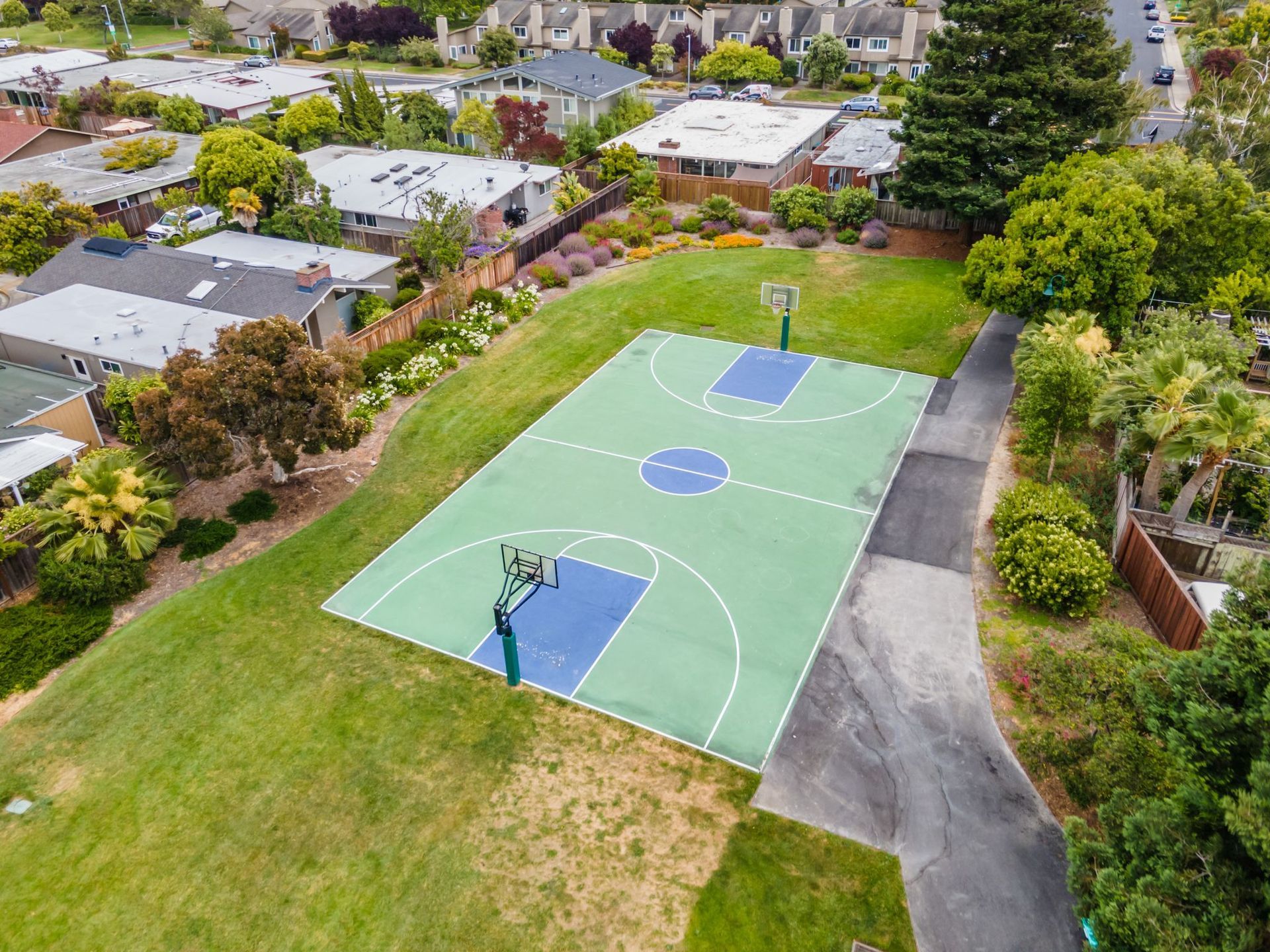 An aerial view of a basketball court in a residential area.