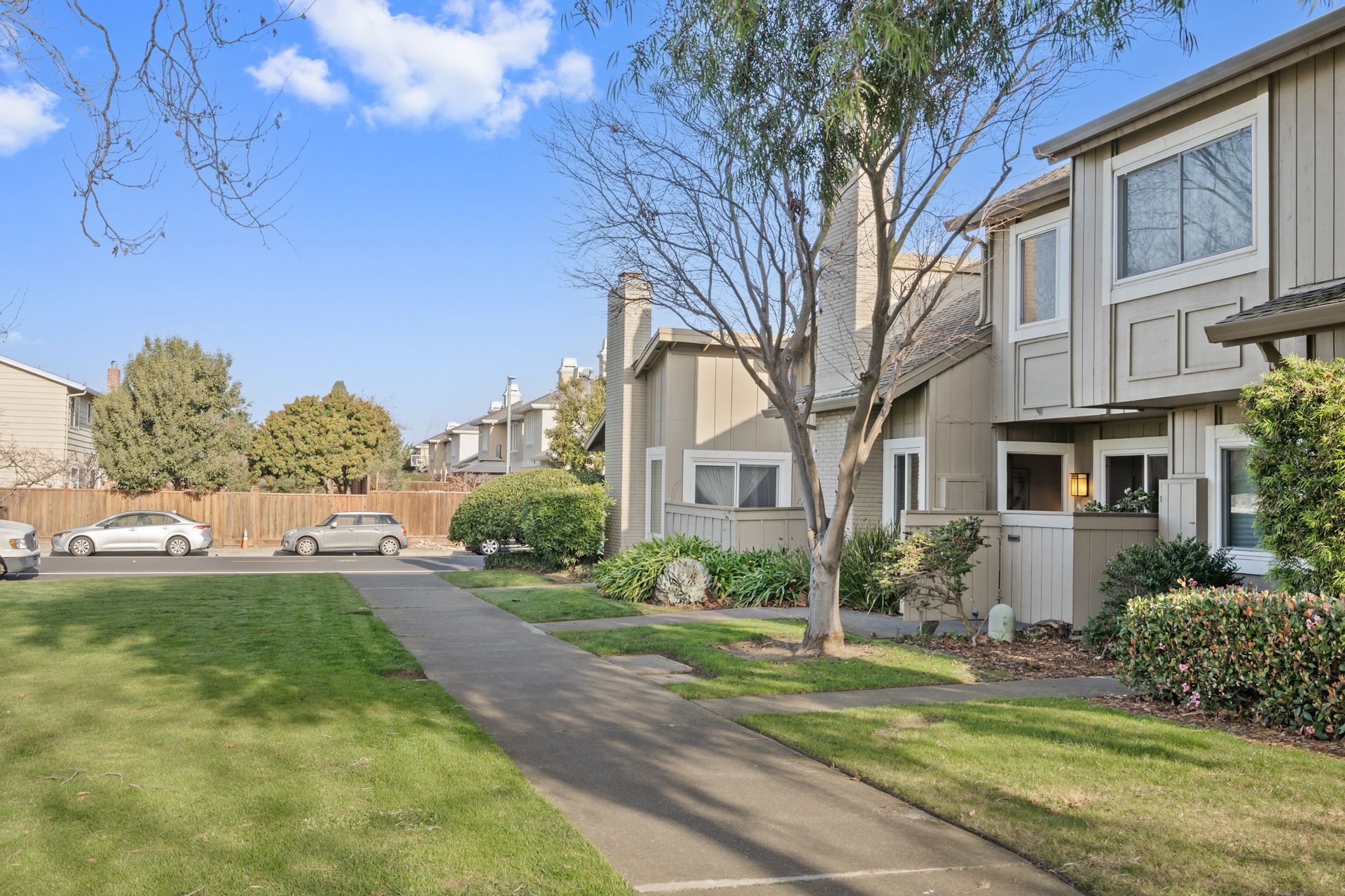 A row of houses with cars parked in front of them in a residential area.