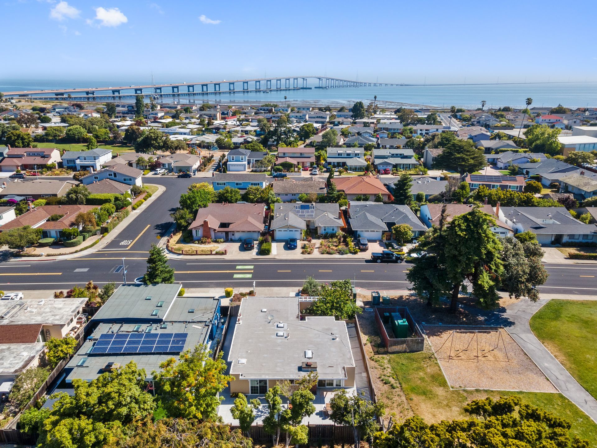 An aerial view of a residential area with a bridge in the background
