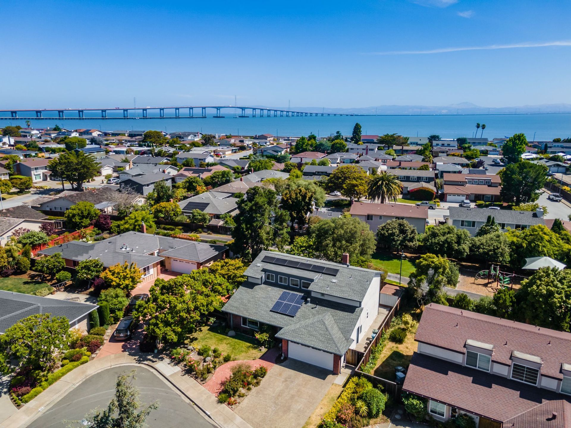 An aerial view of a residential area with a bridge in the background.