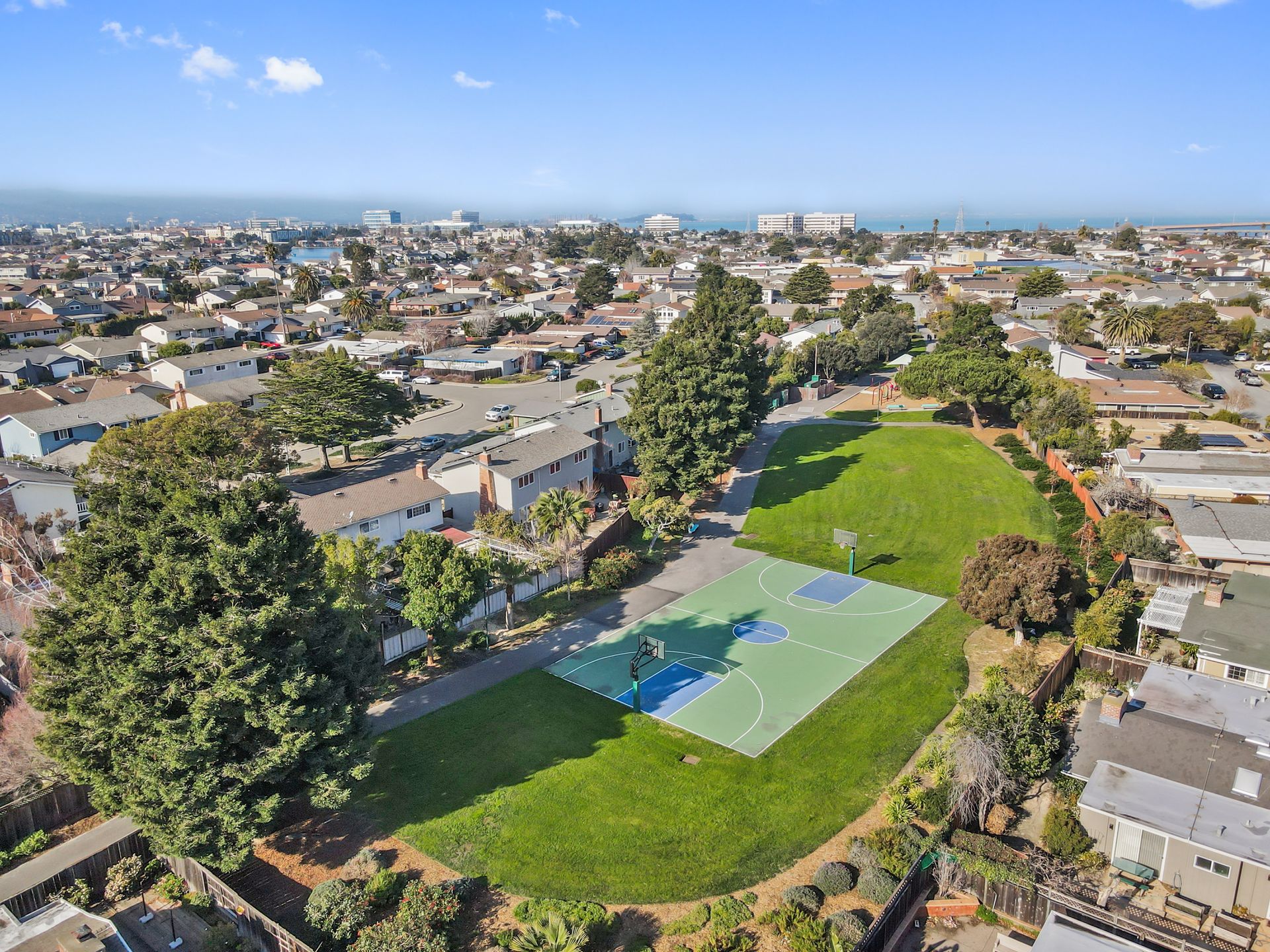 An aerial view of a tennis court in a residential area