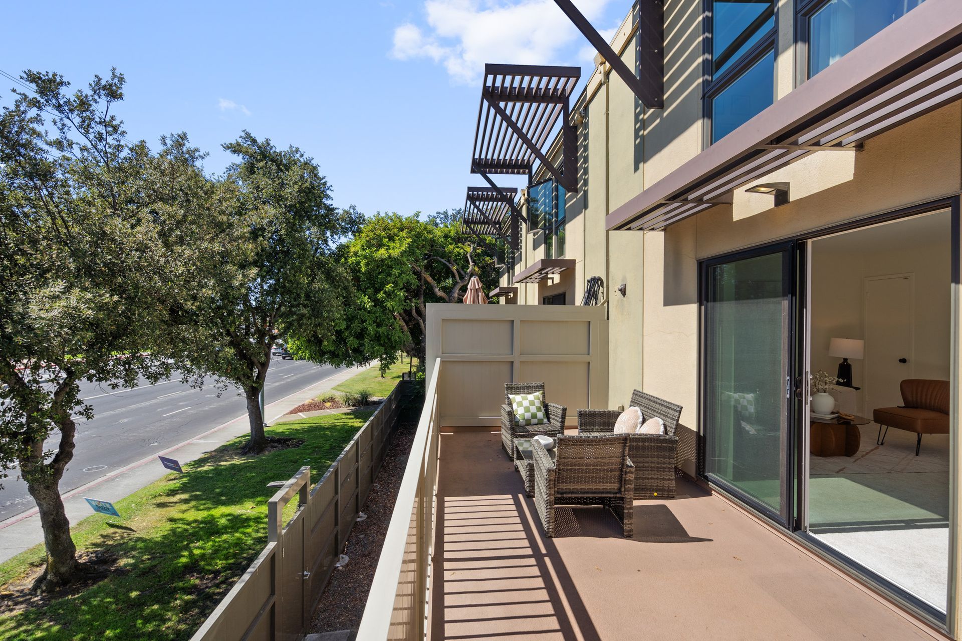 A balcony with a couch and chairs in front of a building