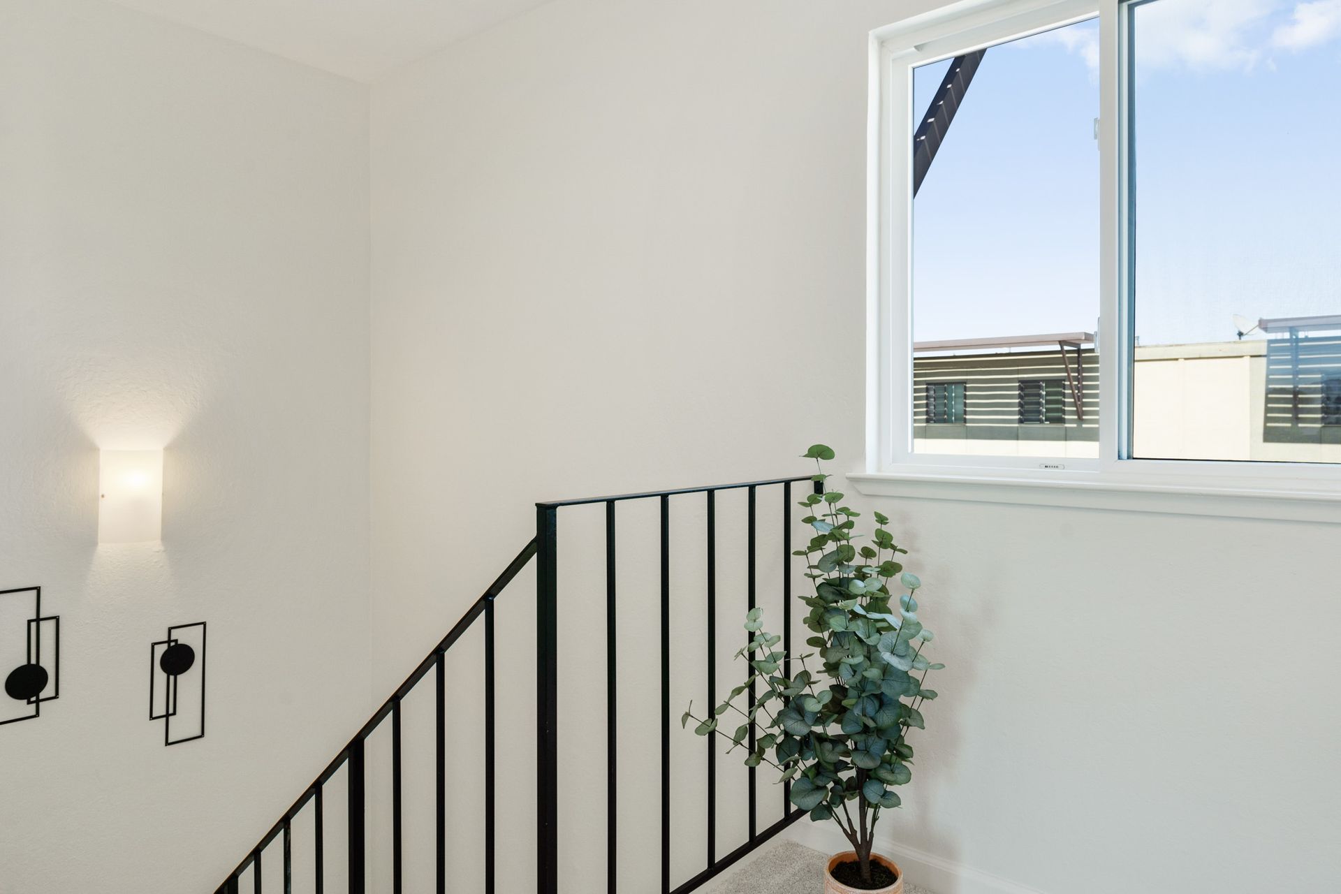 A staircase with a plant in a pot and a window.