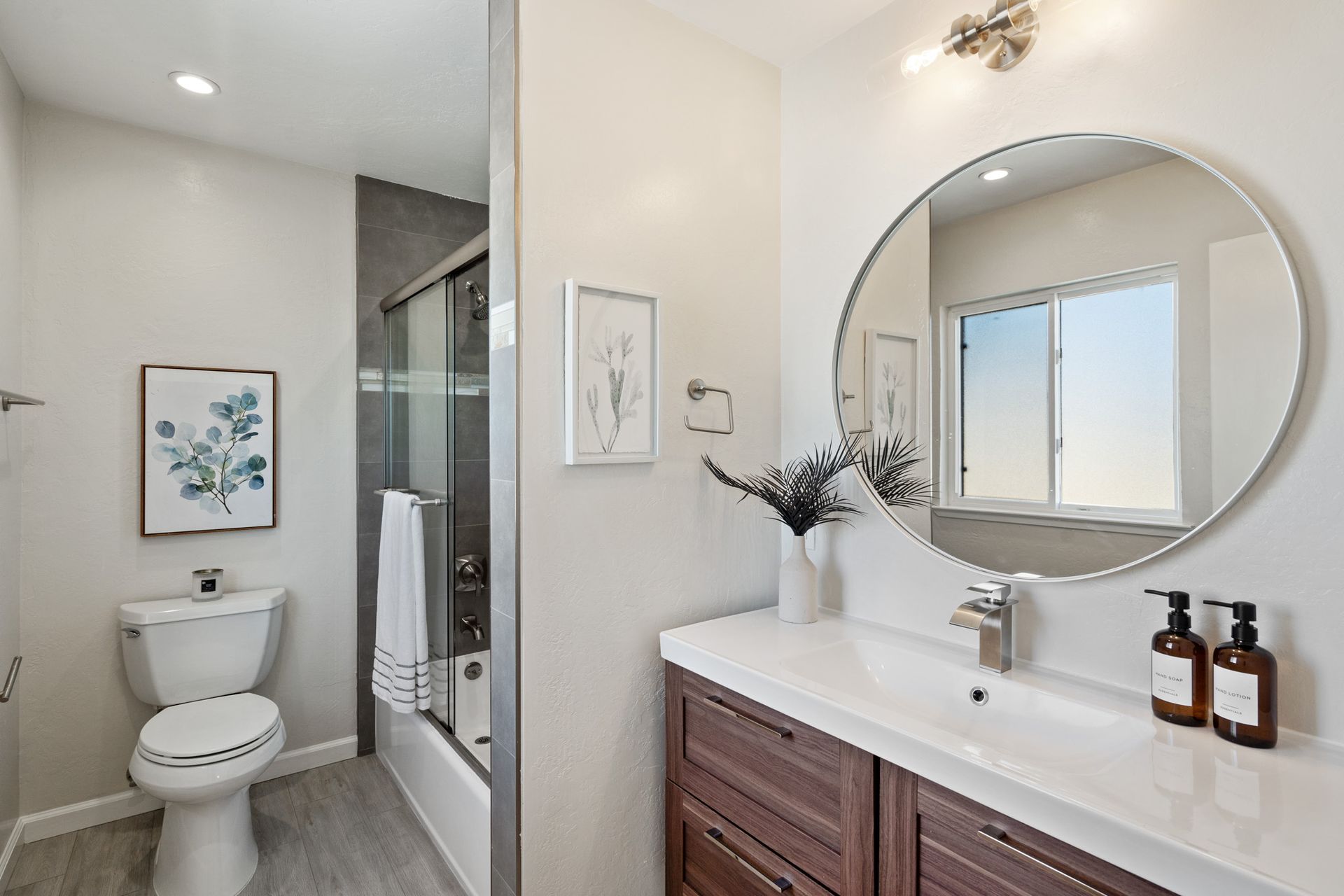 A bathroom with a toilet , sink , and mirror.