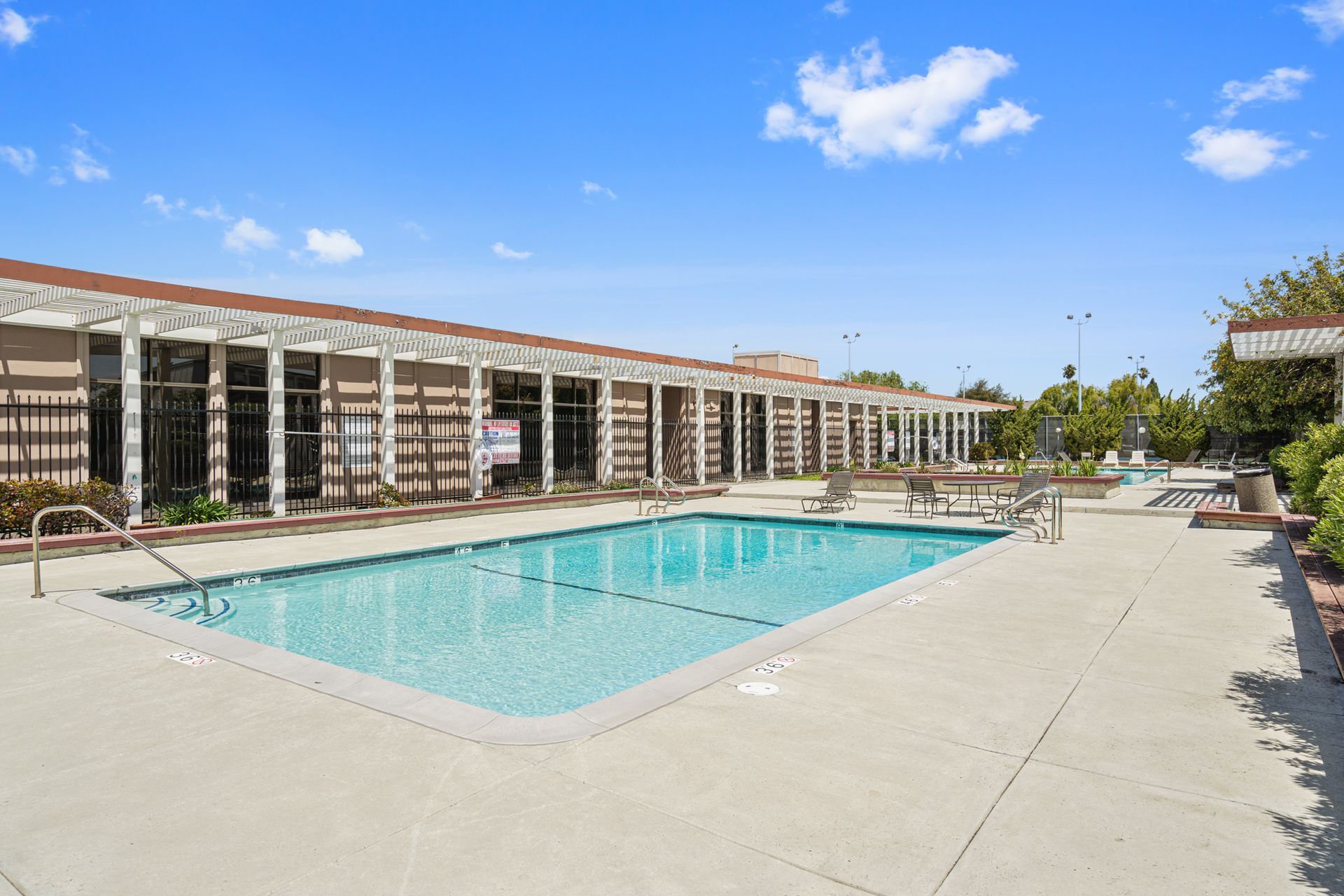There is a large swimming pool in front of a building.