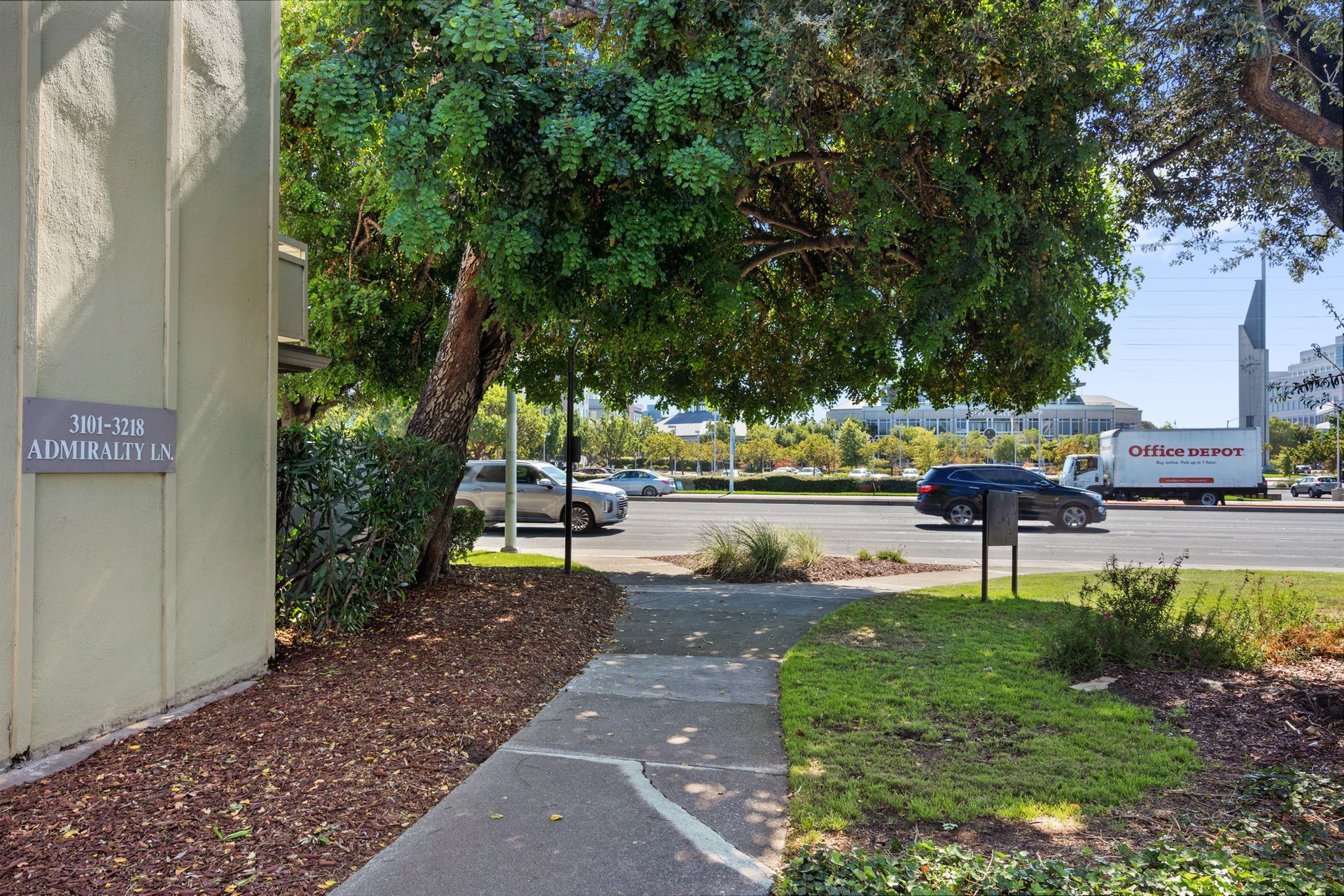 A sidewalk leading to a building with a sign on it