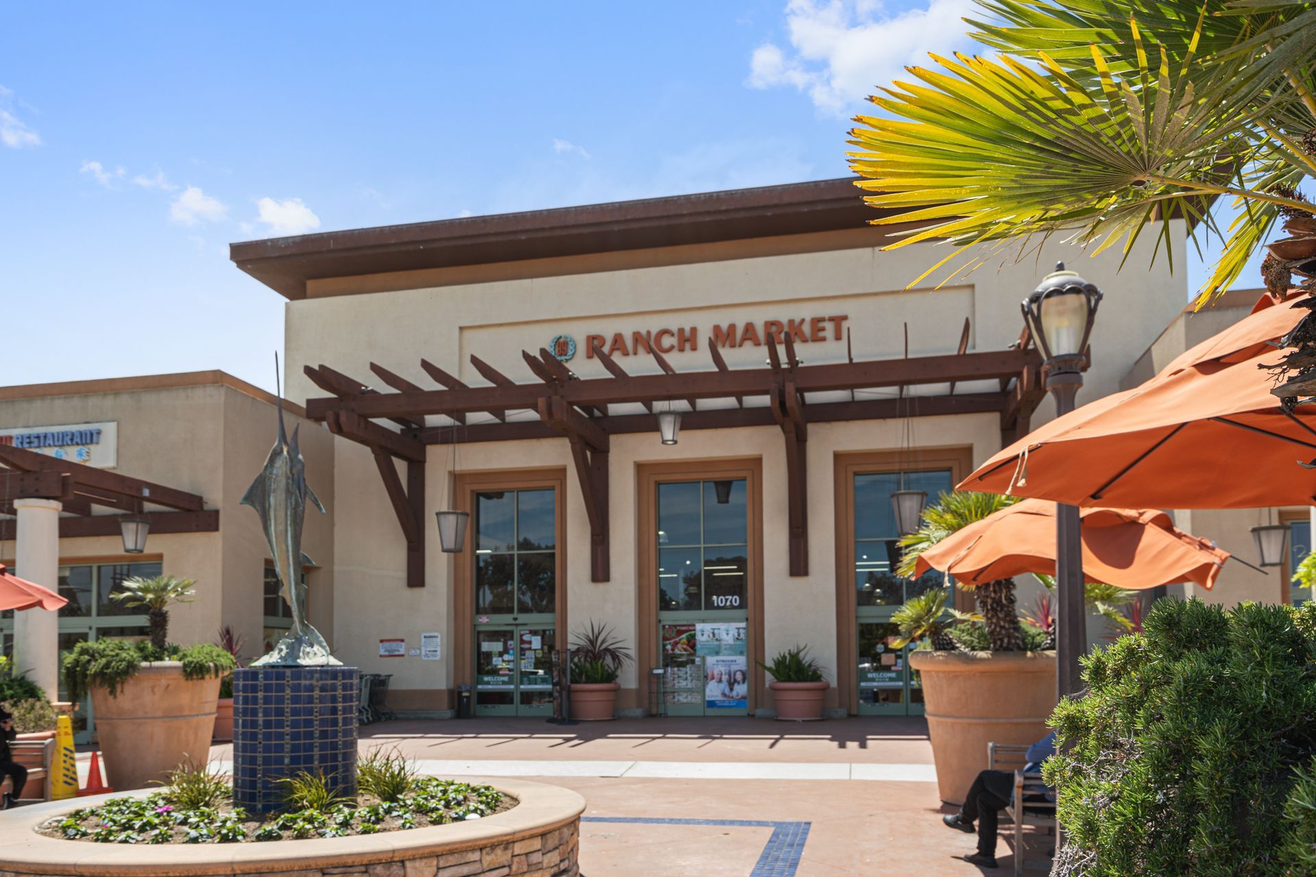 The front of a ranch market with umbrellas in front of it