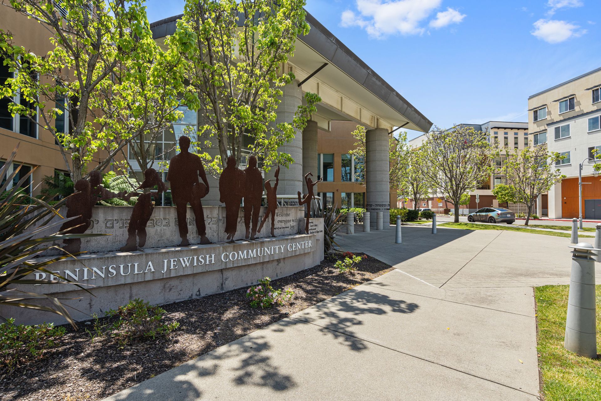 A large building with a sign in front of it that says ' peninsula jewish community center ' on it.