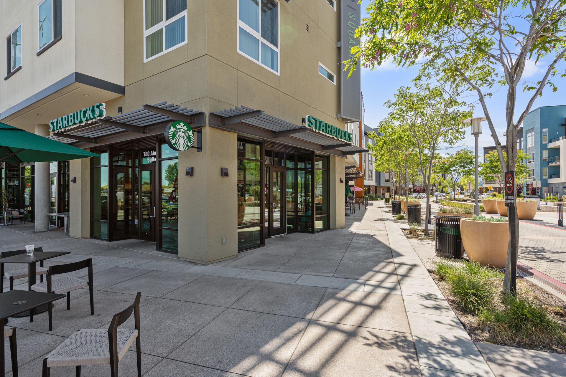 A starbucks coffee shop is located on the corner of a building.