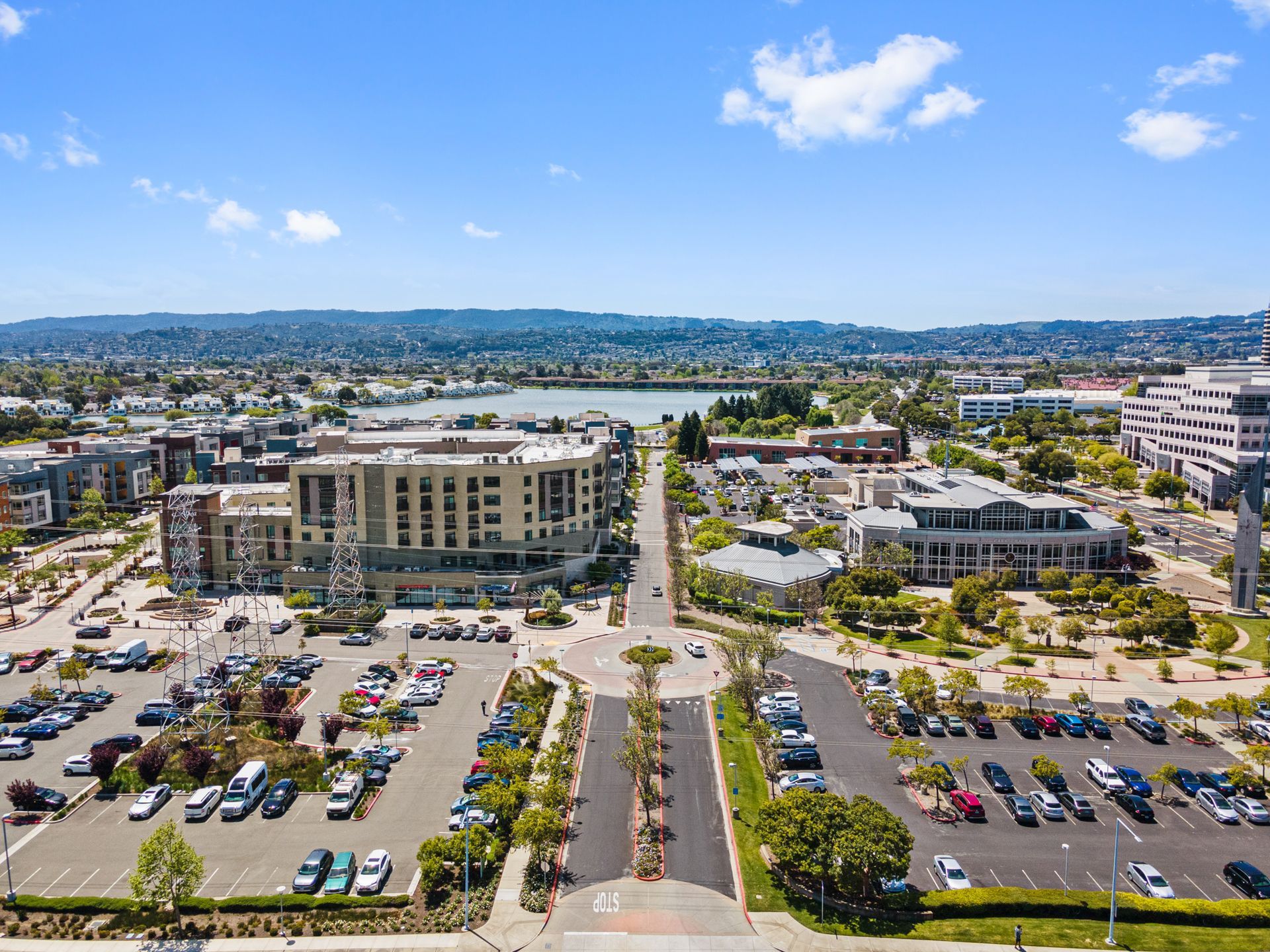 An aerial view of a city with a lot of cars parked in a parking lot.