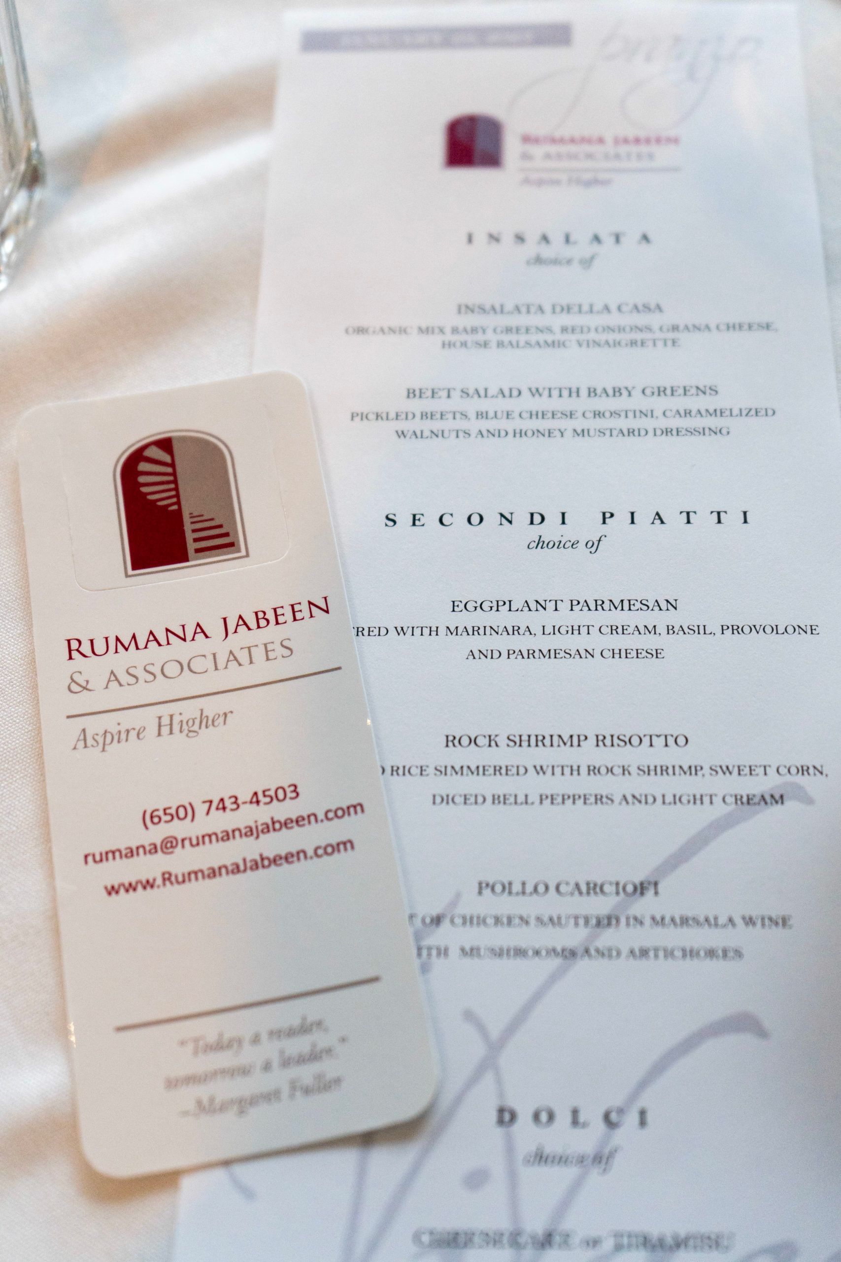 A business card for nimana japans & associates sits next to a menu