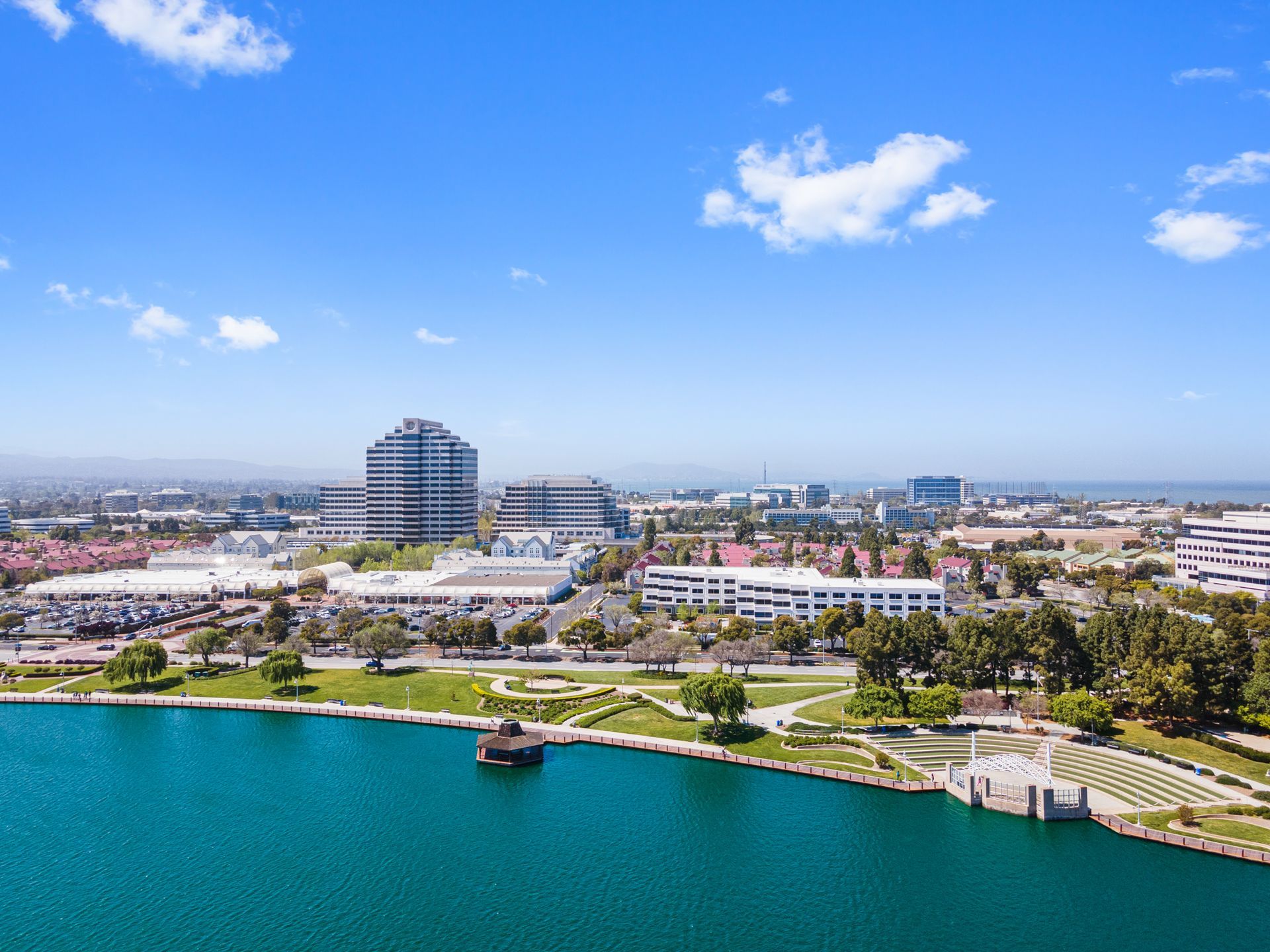 An aerial view of a city with a lake in the foreground.