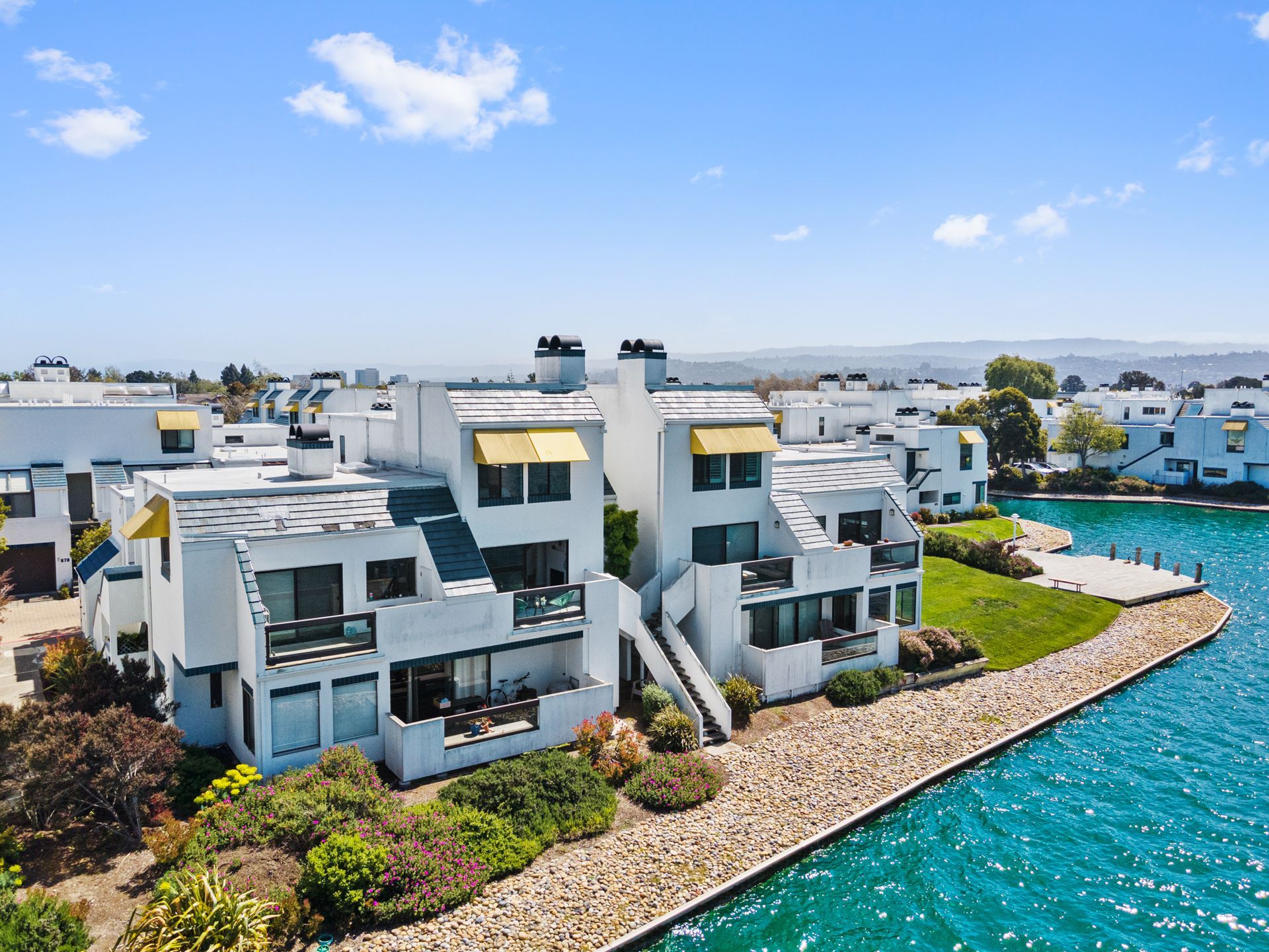 An aerial view of a row of houses next to a body of water.
