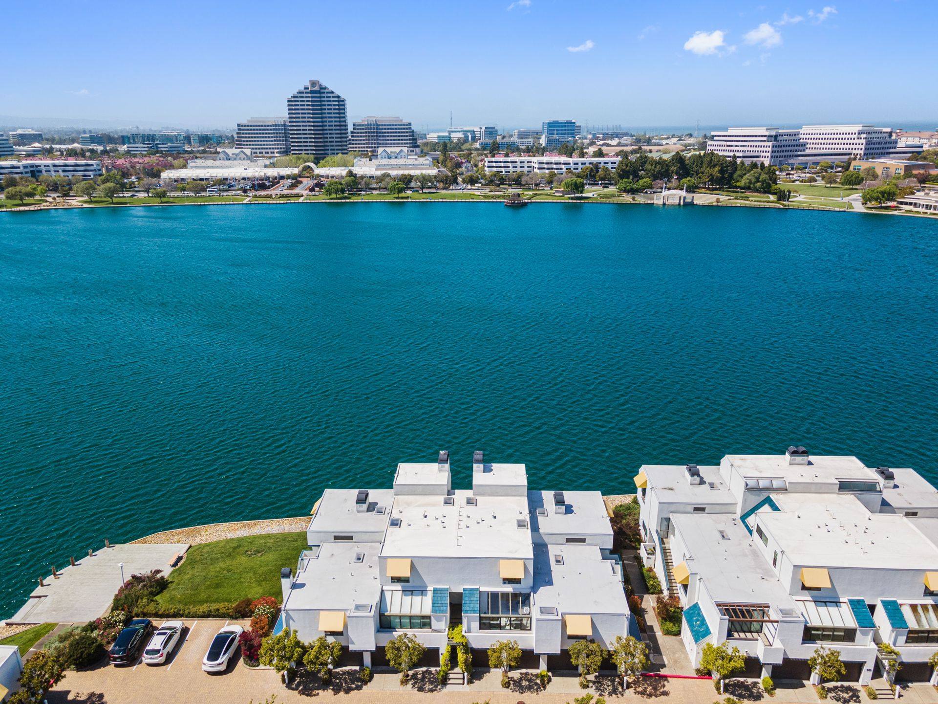 An aerial view of a lake with buildings in the foreground