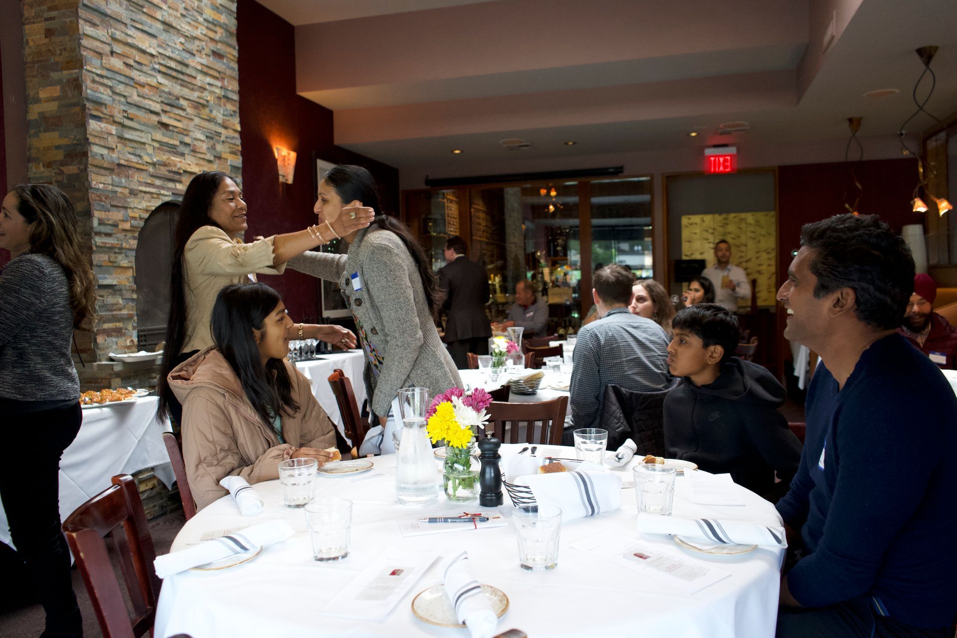 A group of people are sitting at tables in a restaurant.