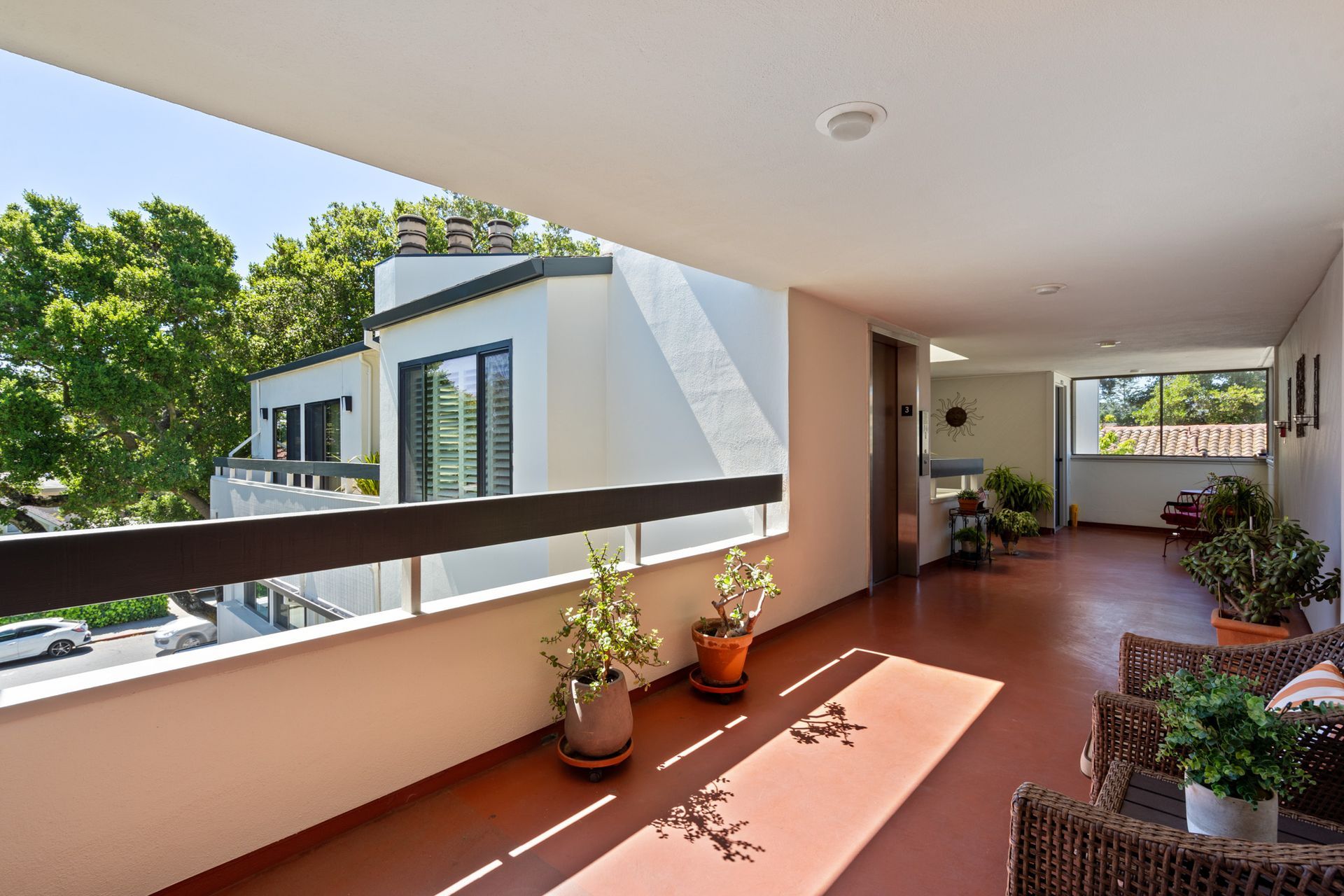 A balcony with a rug and chairs and plants on it