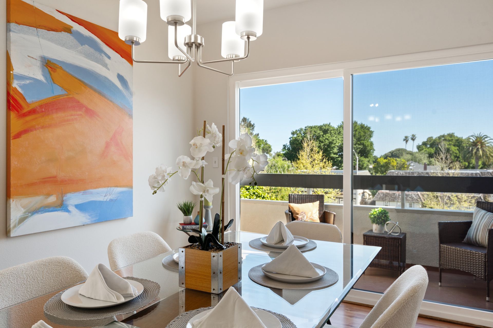 A dining room with a table and chairs and a painting on the wall