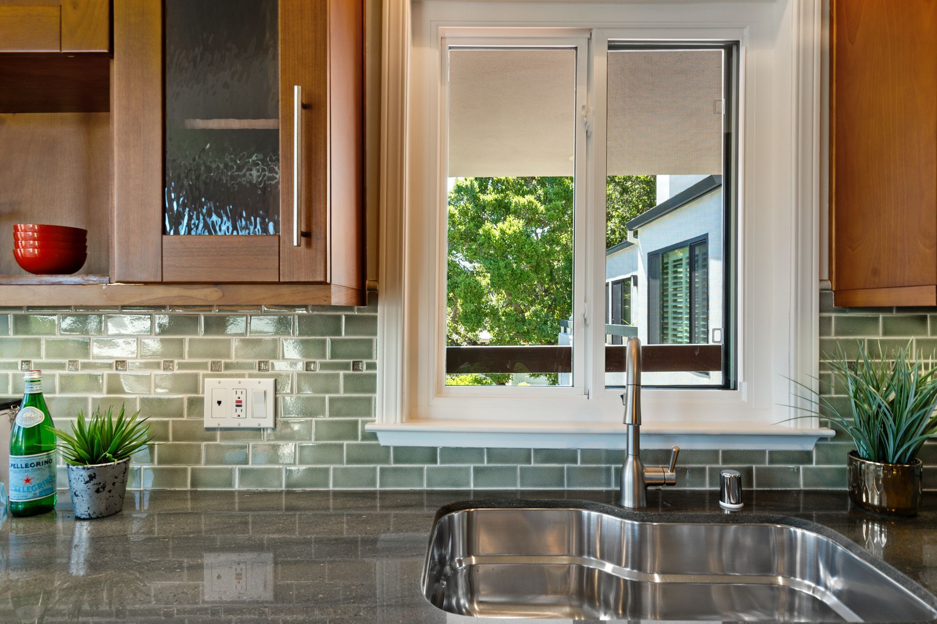 A kitchen with a stainless steel sink and a window.