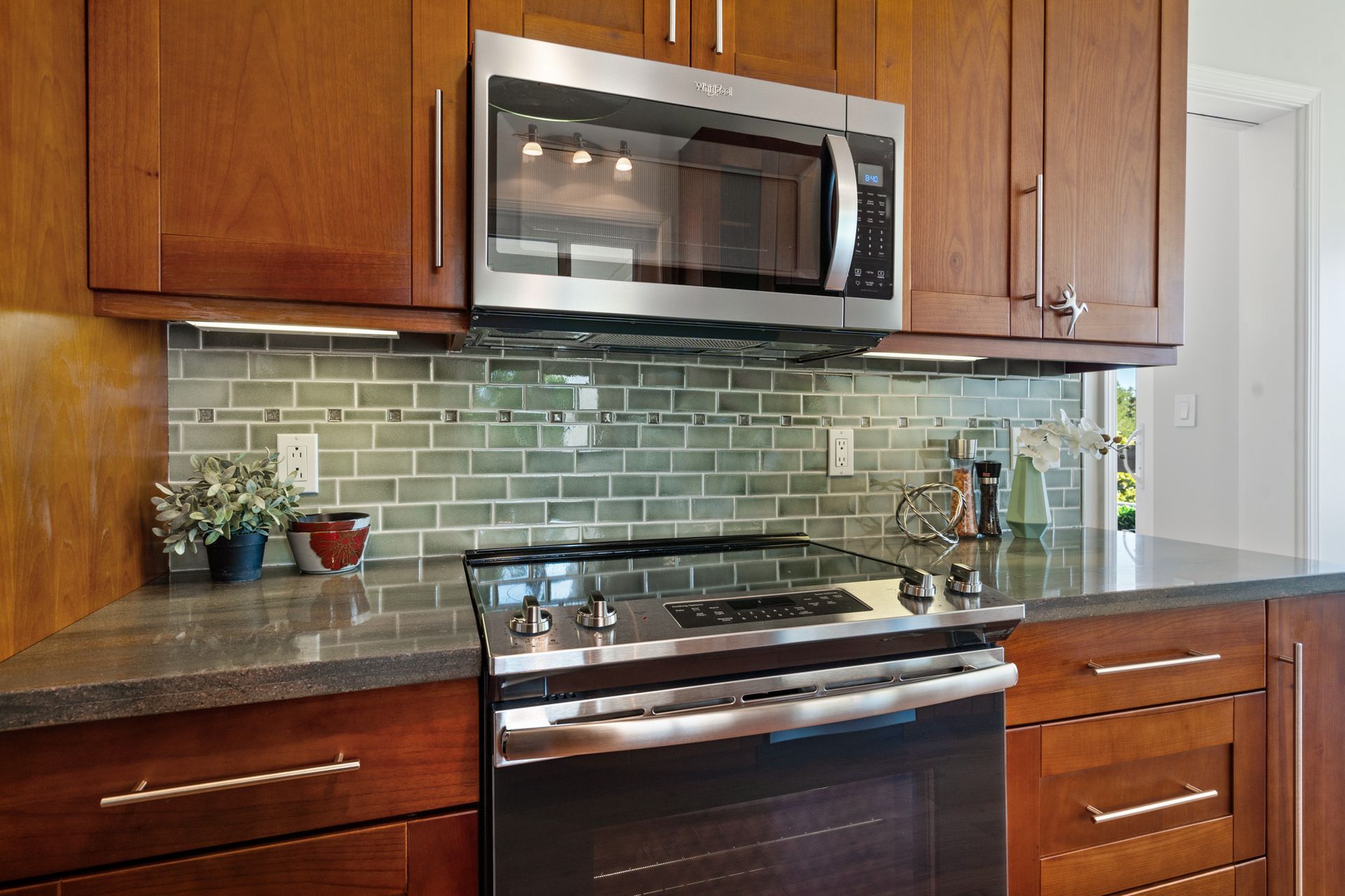 A kitchen with stainless steel appliances and wooden cabinets.