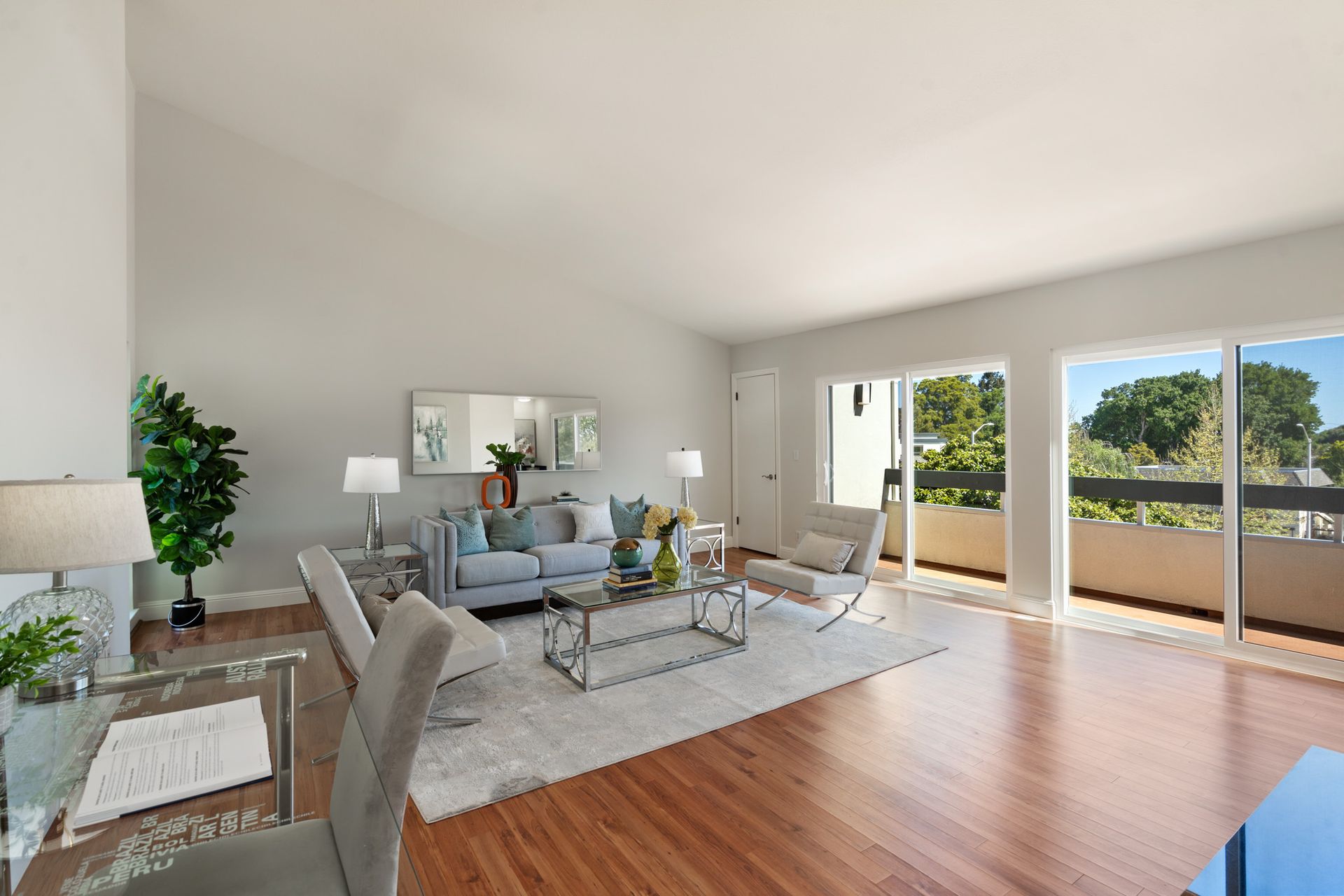 A living room with a couch , chairs , coffee table and sliding glass doors.
