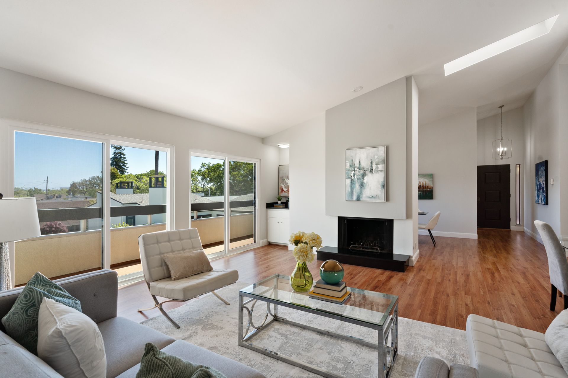 A living room with a couch , chairs , coffee table and fireplace.