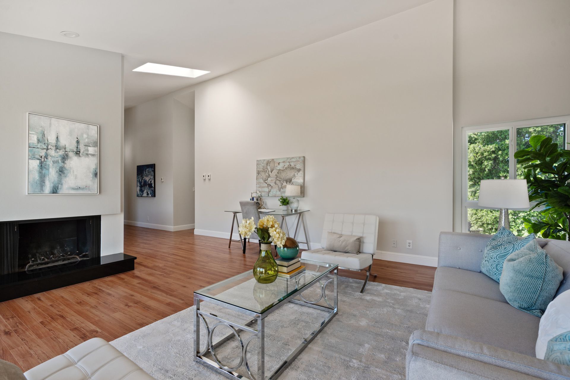A living room with a couch , chair , coffee table and fireplace.