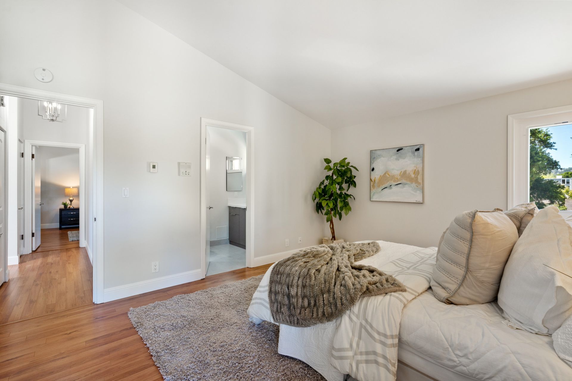 A bedroom with a bed , couch , rug and a window.