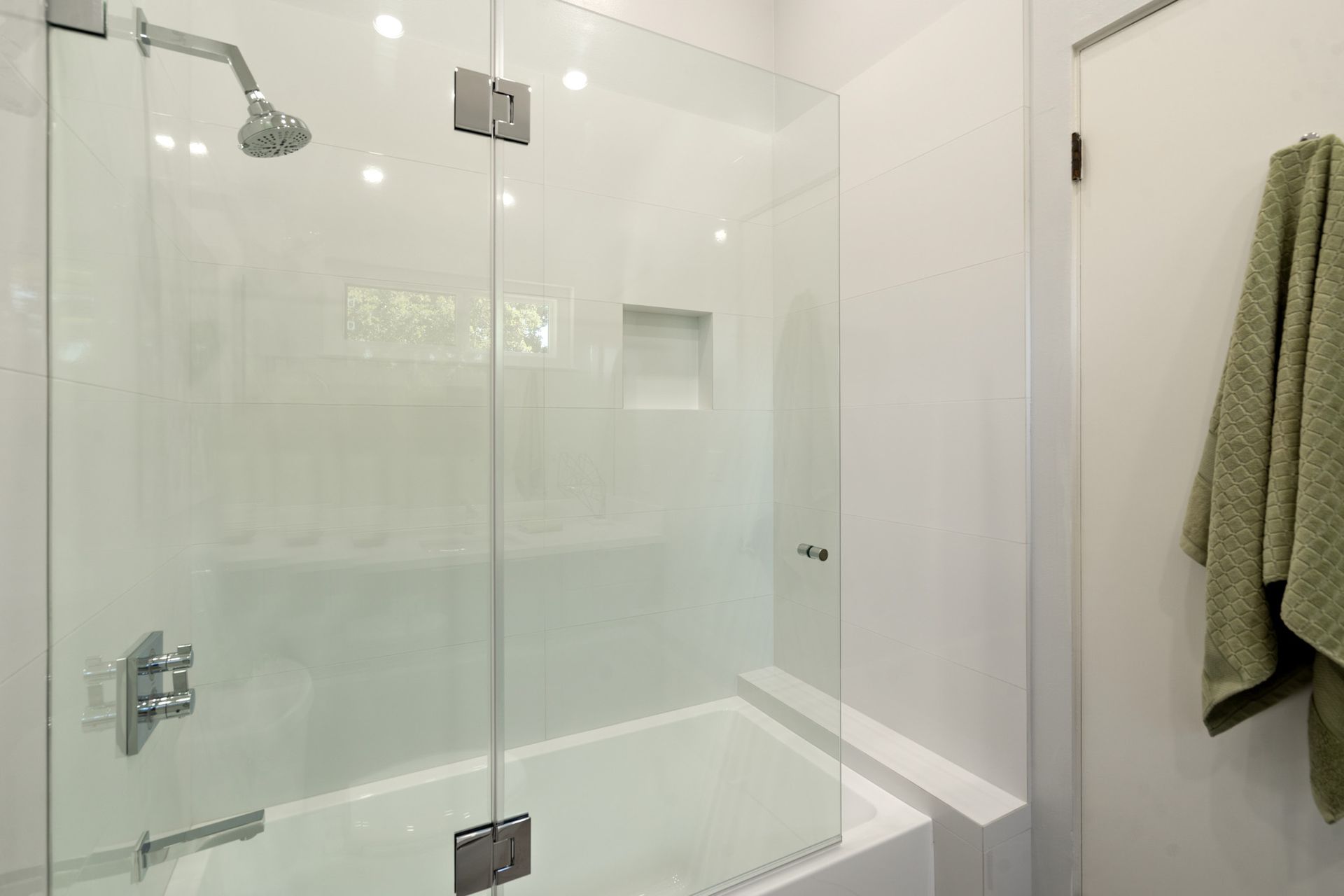 A bathroom with a bathtub and a shower with a glass door.