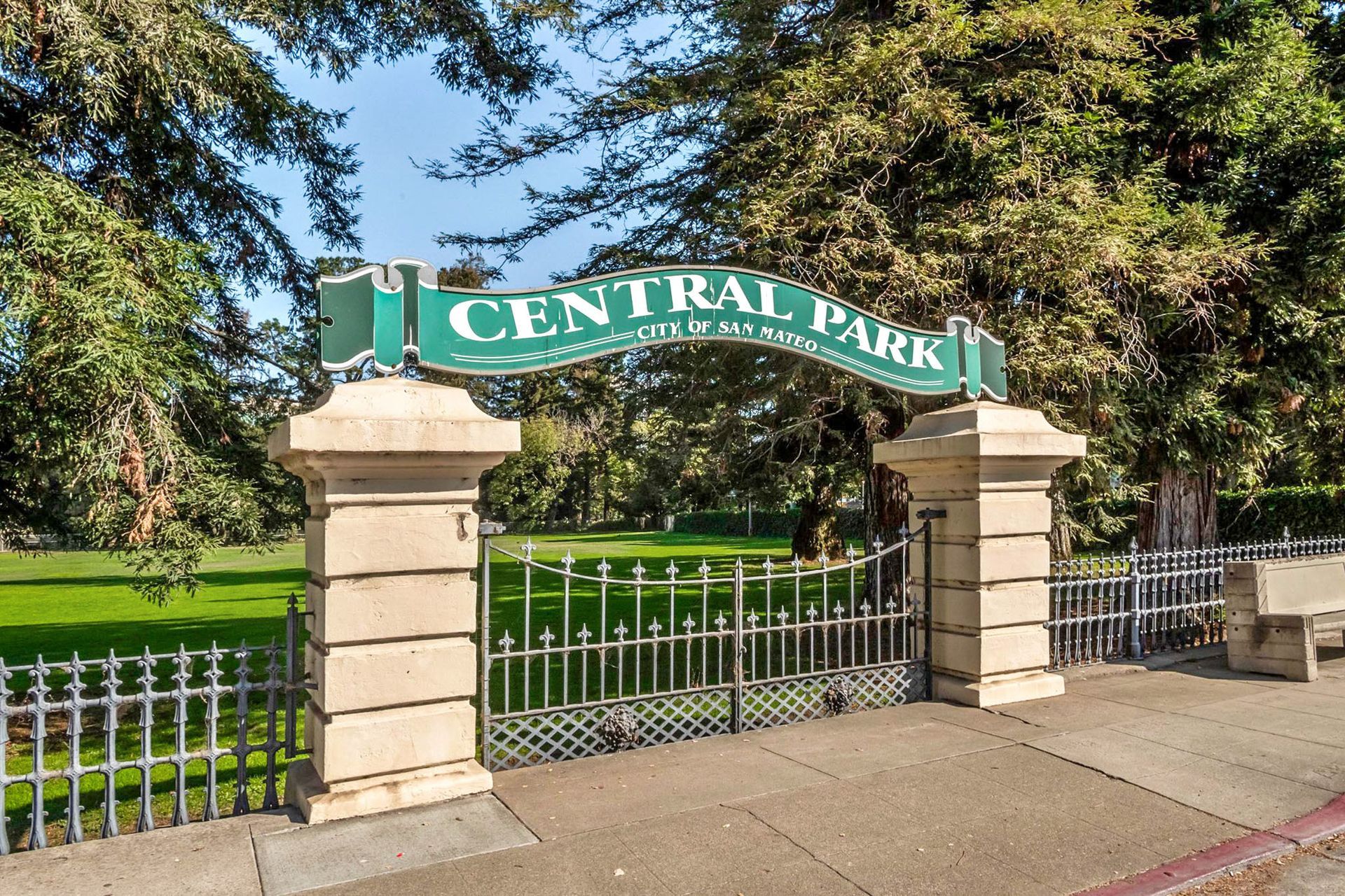 A sign for central park is above a gate