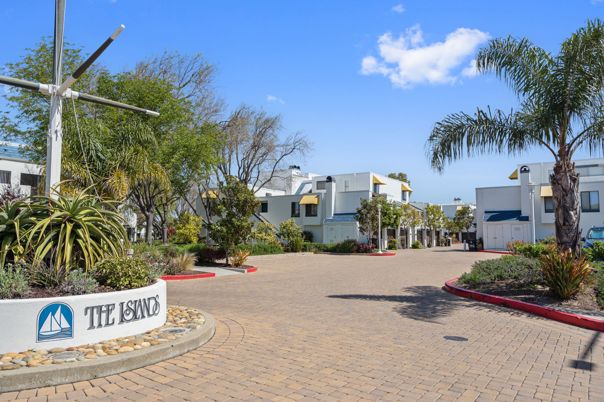 A sign for the islands is in the middle of a brick driveway