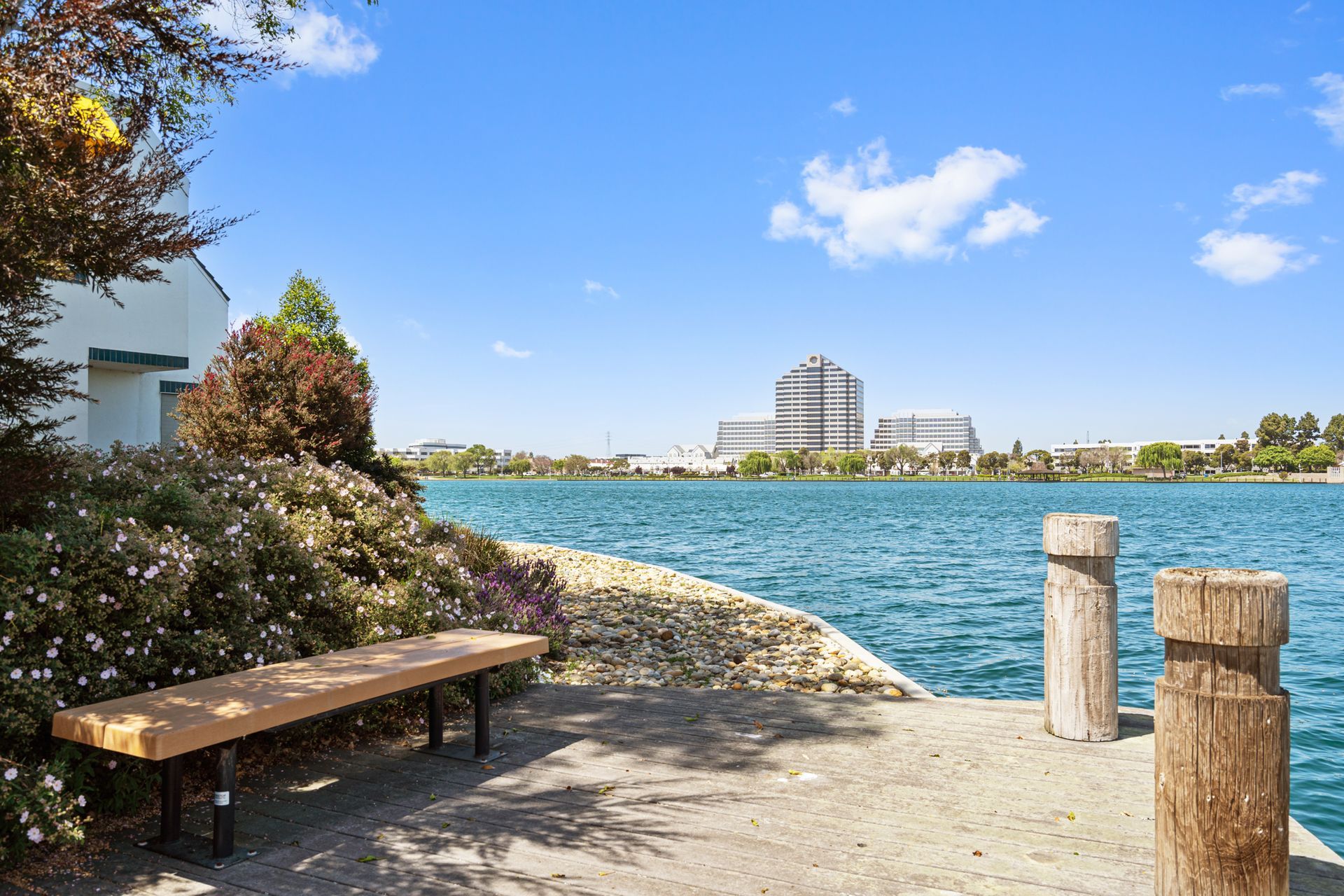 A wooden bench is sitting on a dock overlooking a lake.