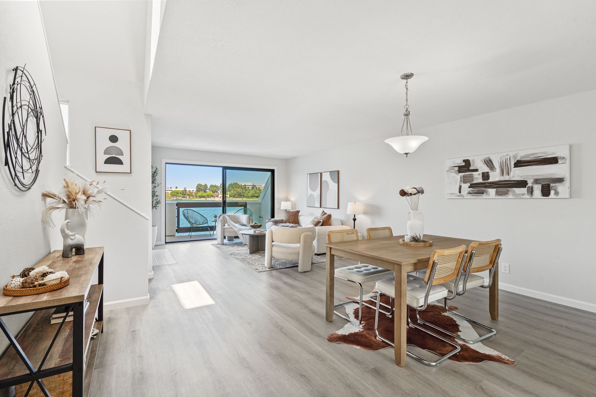 A living room and dining room in a house with a table and chairs.