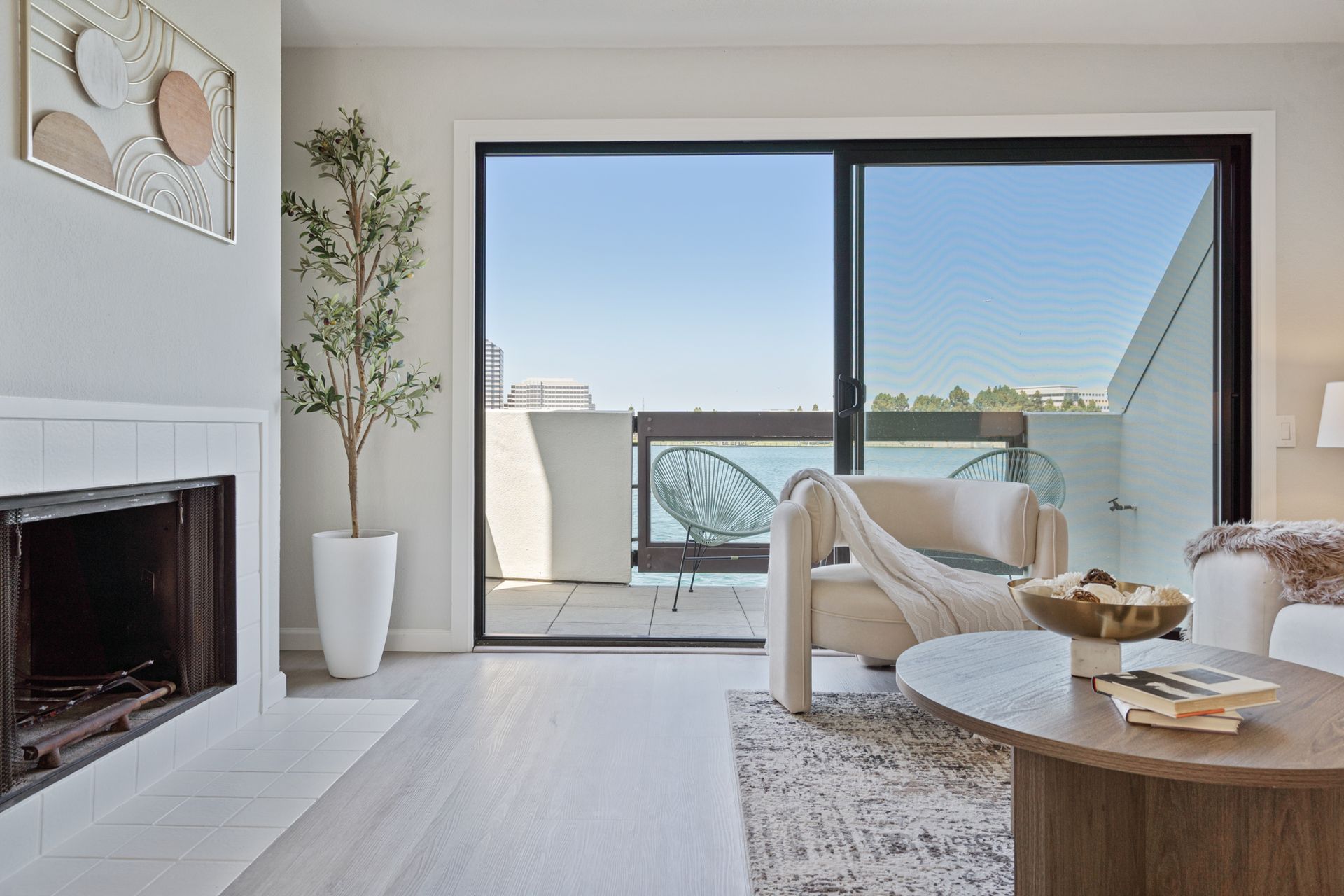 A living room with a fireplace and a sliding glass door leading to a balcony.