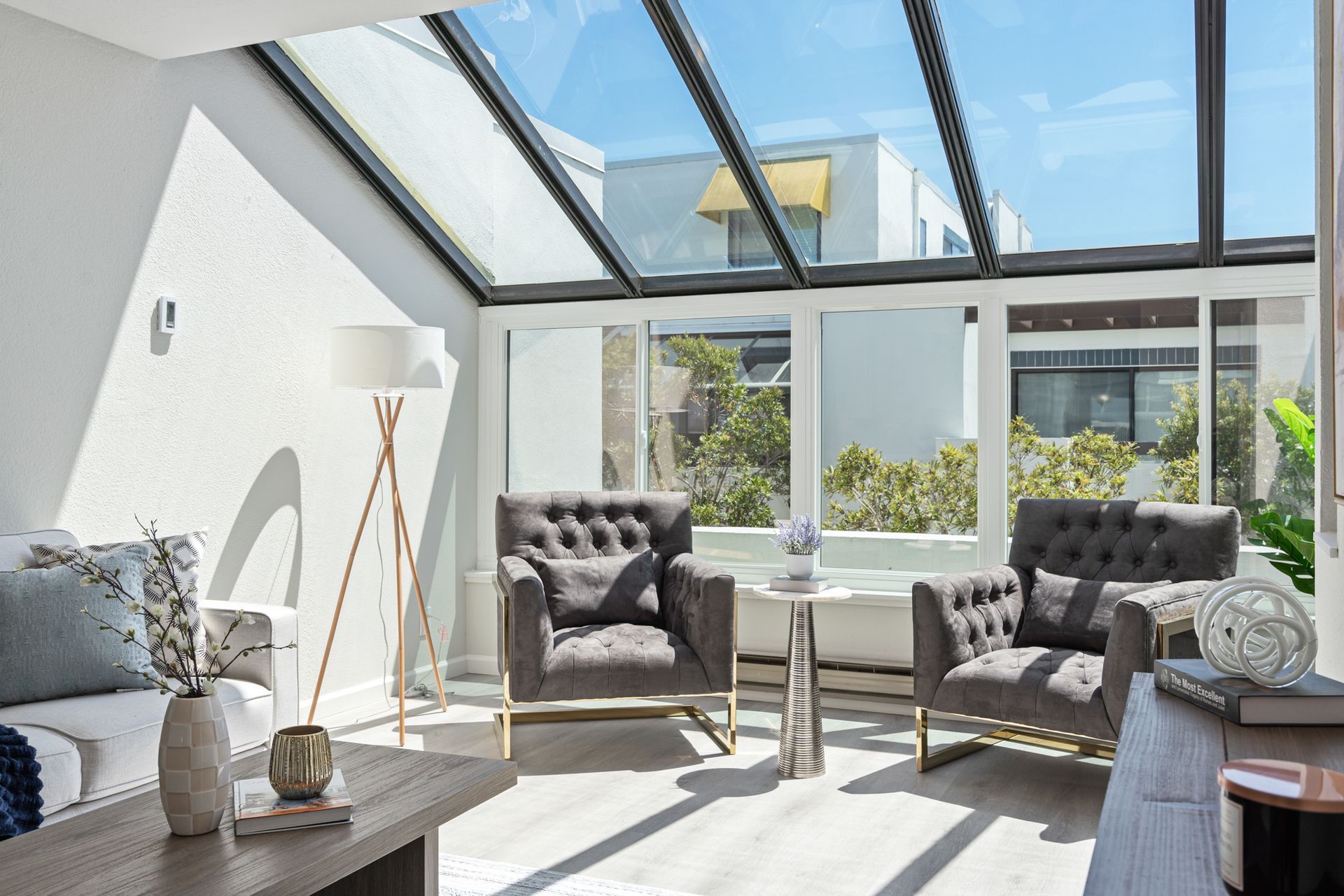 A living room with a lot of windows and chairs.