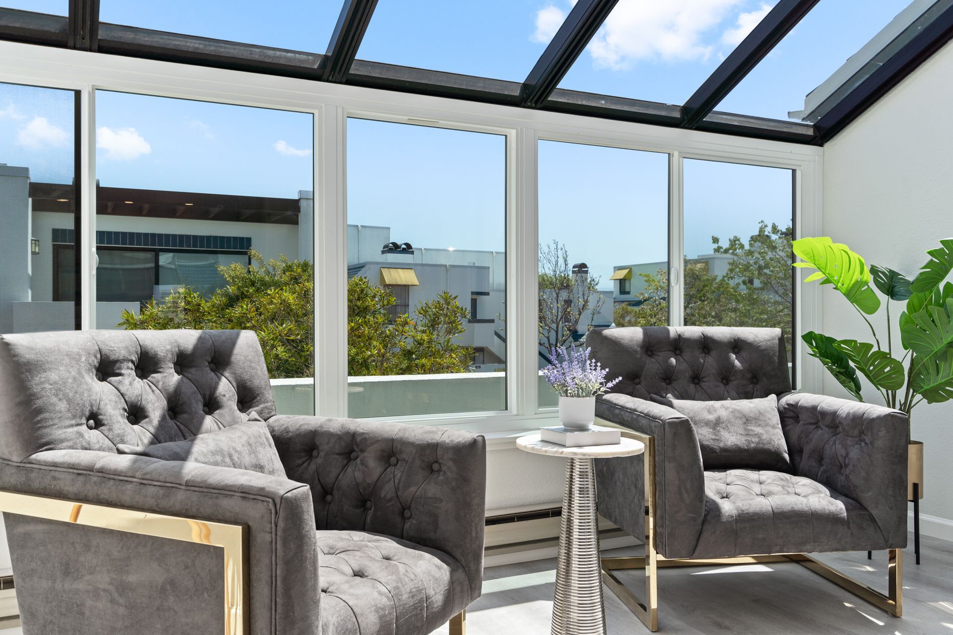 A living room with two chairs and a table with a glass roof.