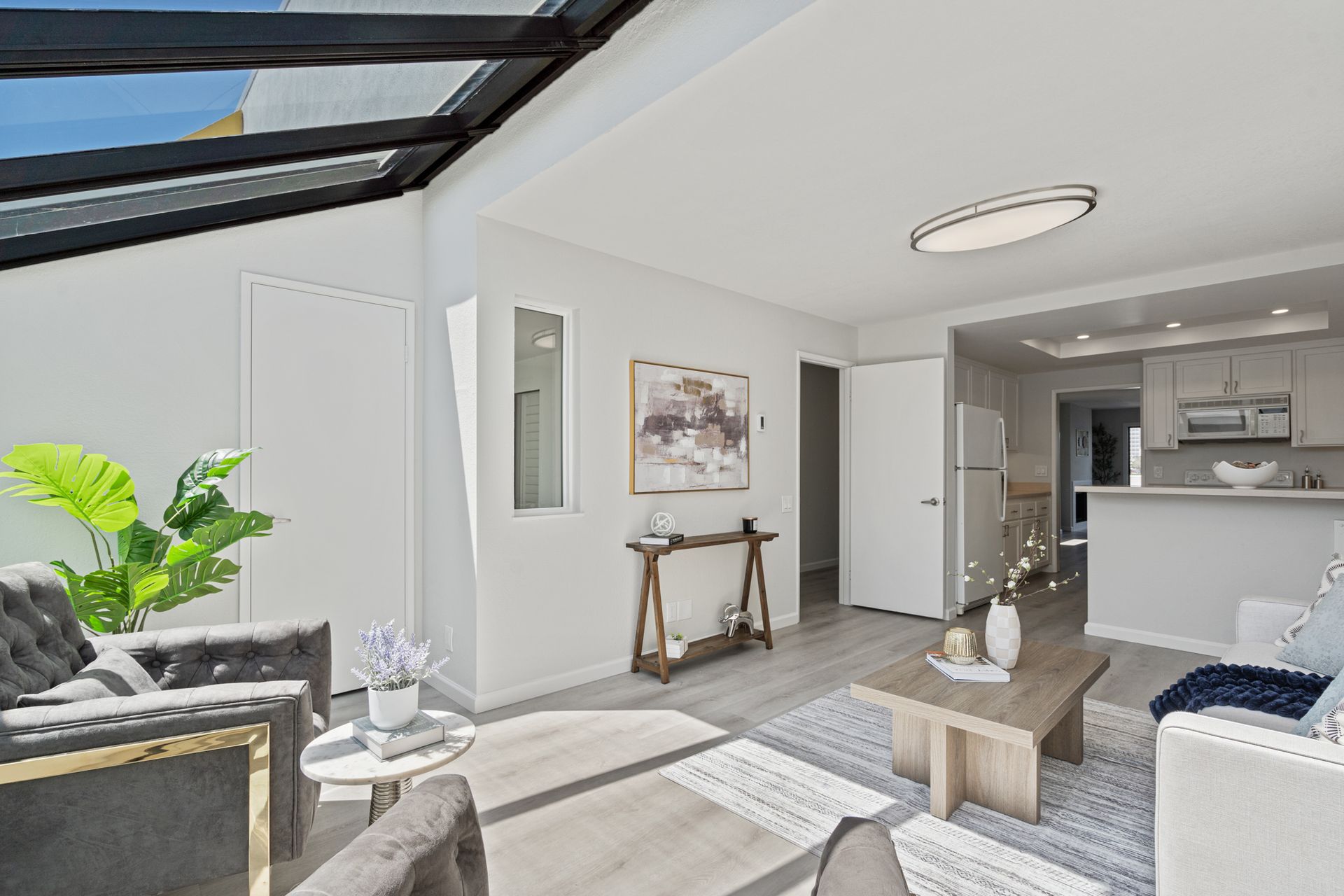 A living room with a couch , chairs , and a coffee table.