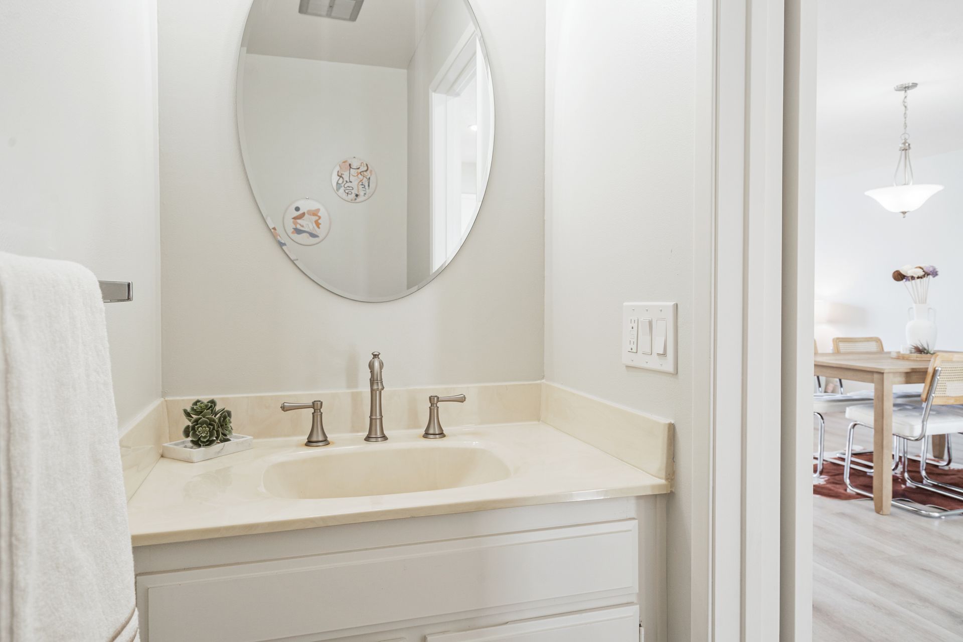A bathroom with a sink , mirror and towel rack.