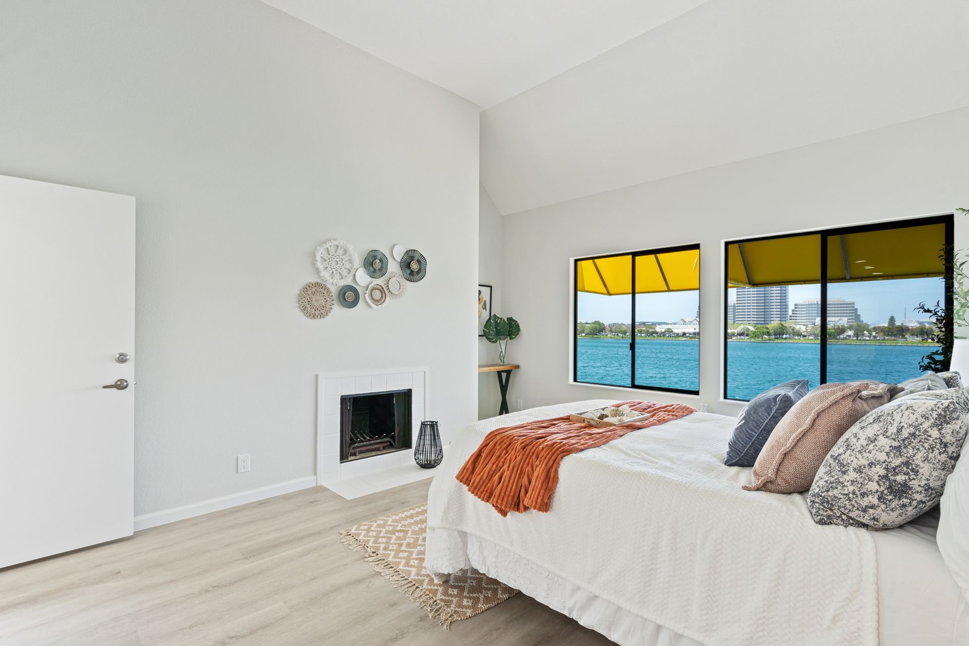 There is a large bed in the middle of the room with a fireplace.