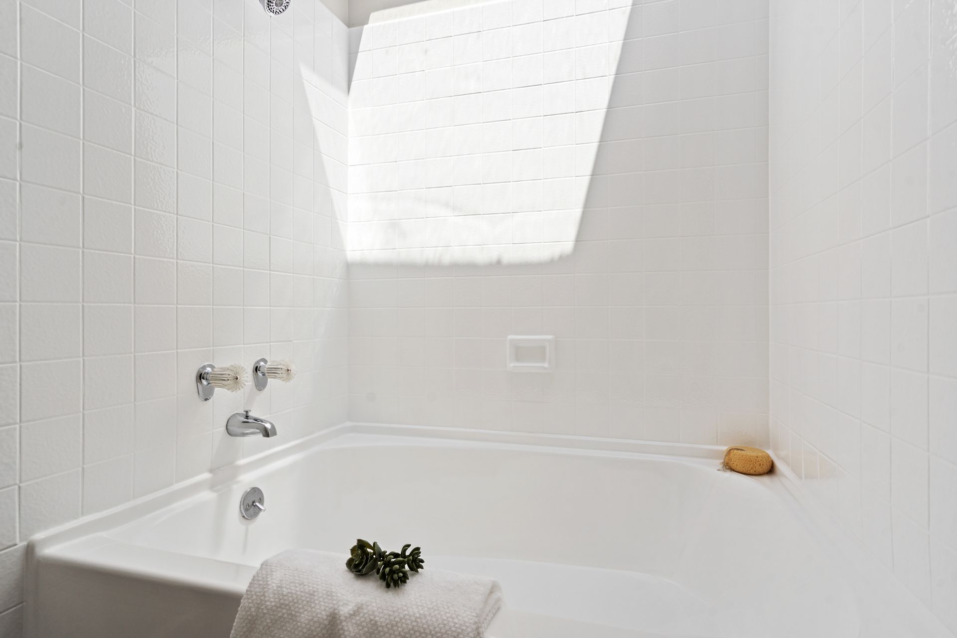 A bathroom with a bathtub and a window.