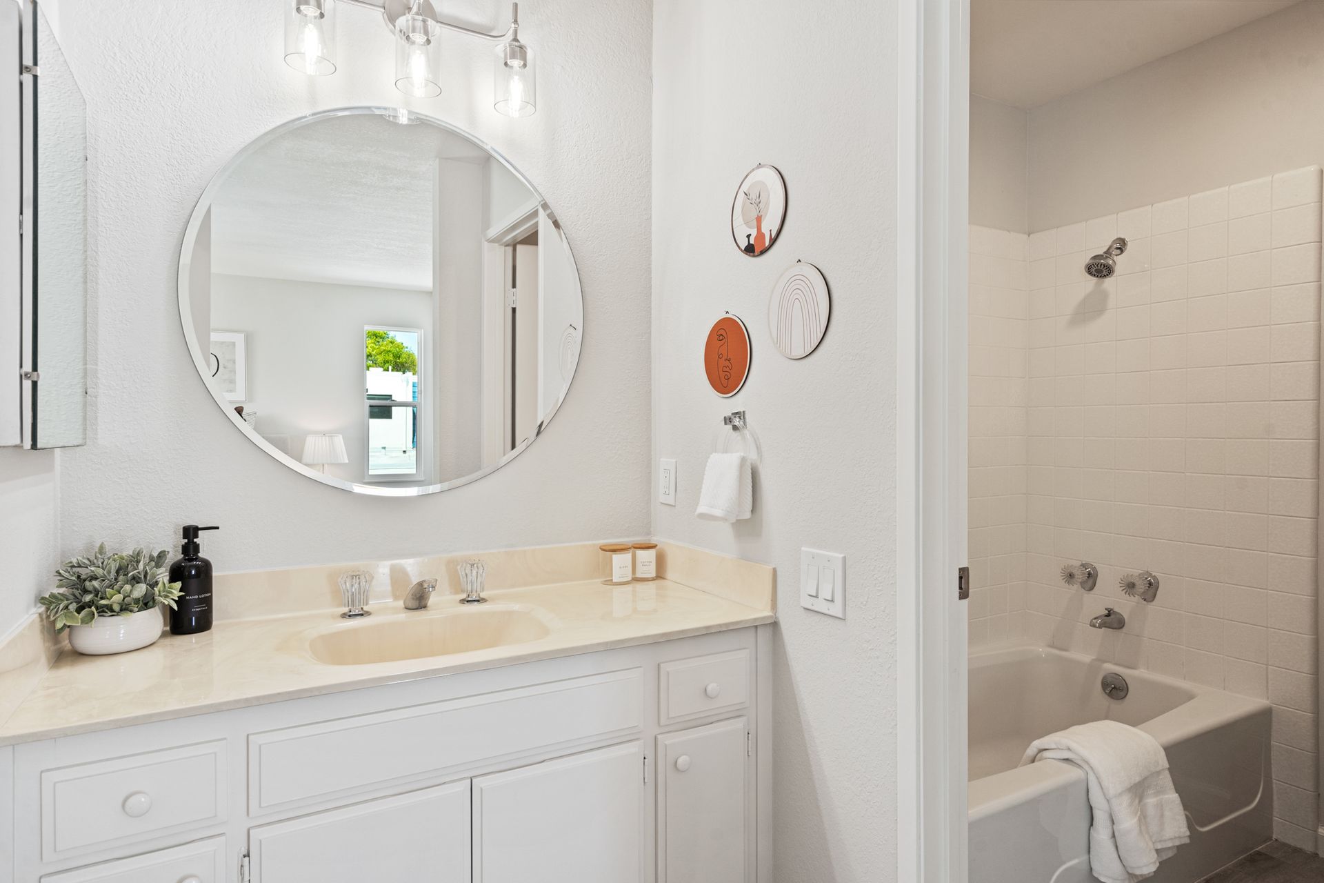 A bathroom with a sink , mirror and bathtub.