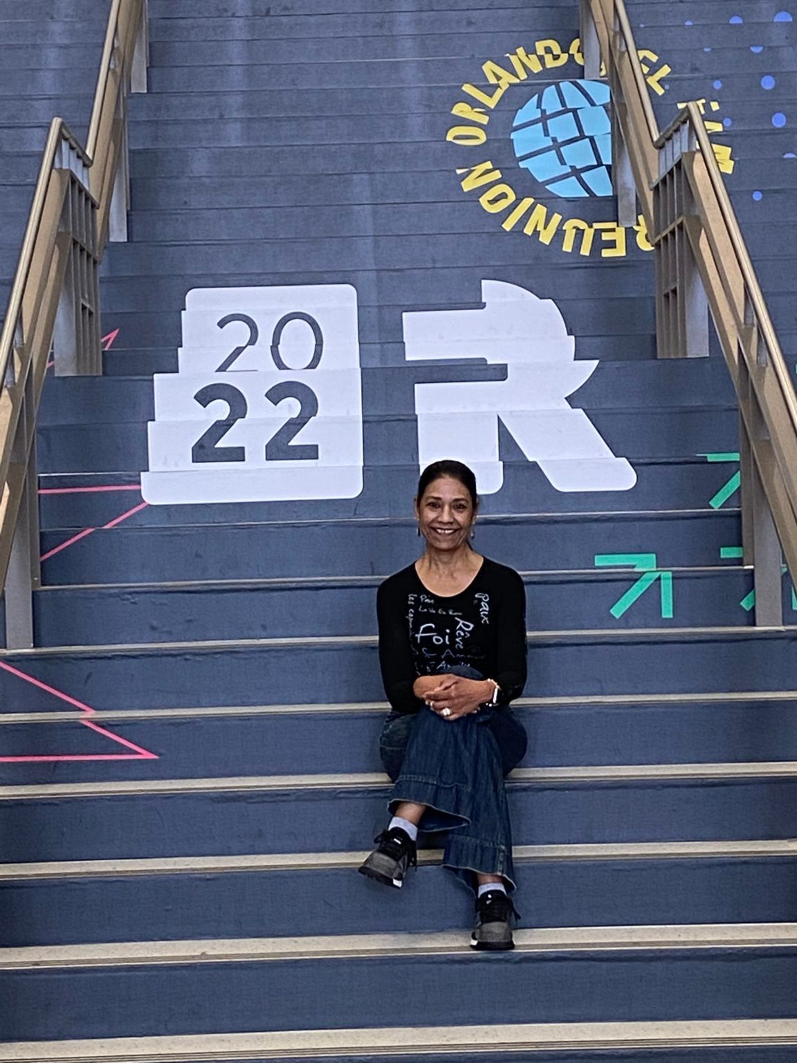 A woman is sitting on a set of stairs with the year 2022 painted on them.