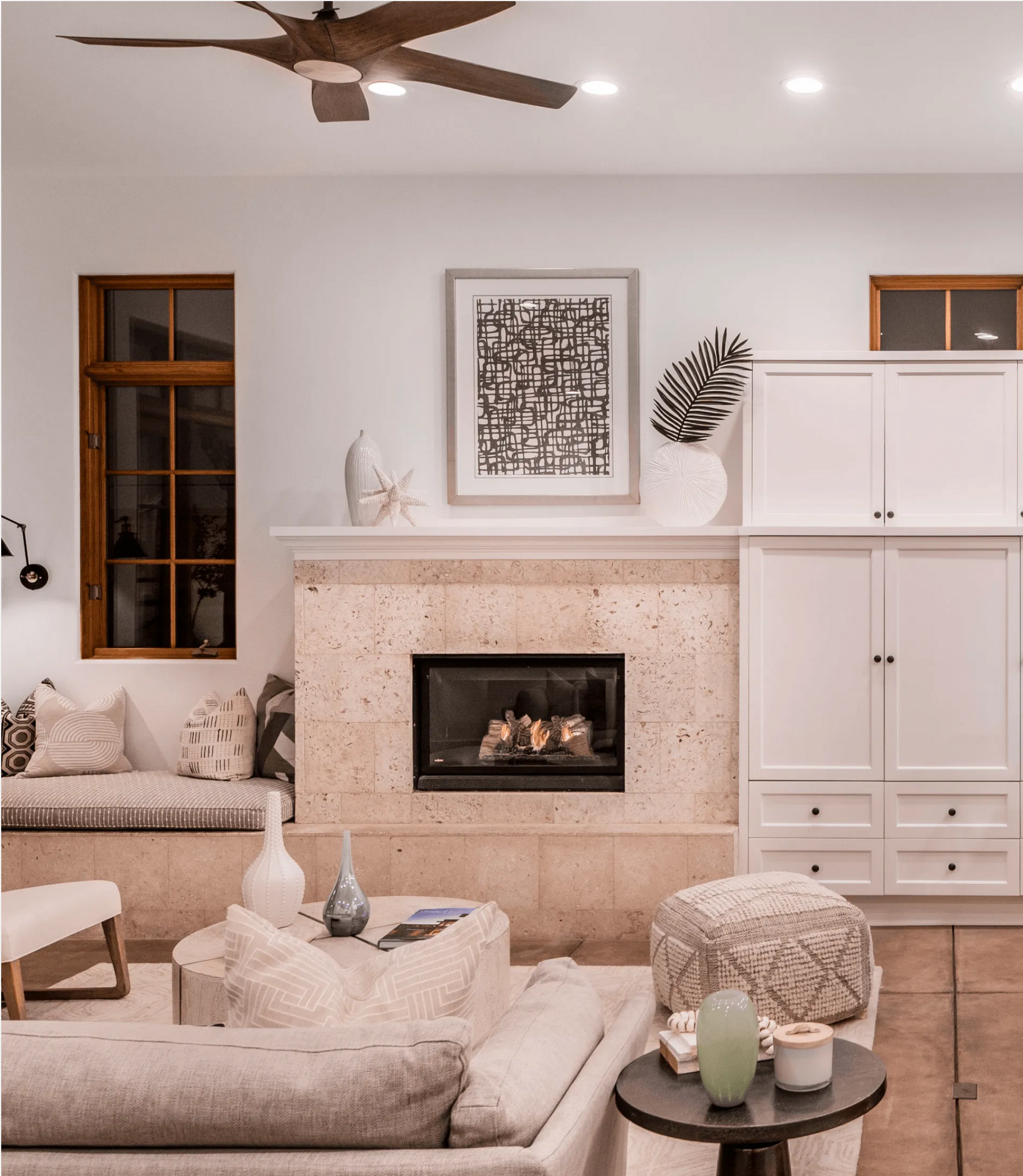 A living room with a fireplace and a ceiling fan