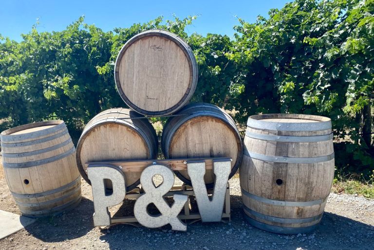 A stack of wooden barrels with the letters p & v on them