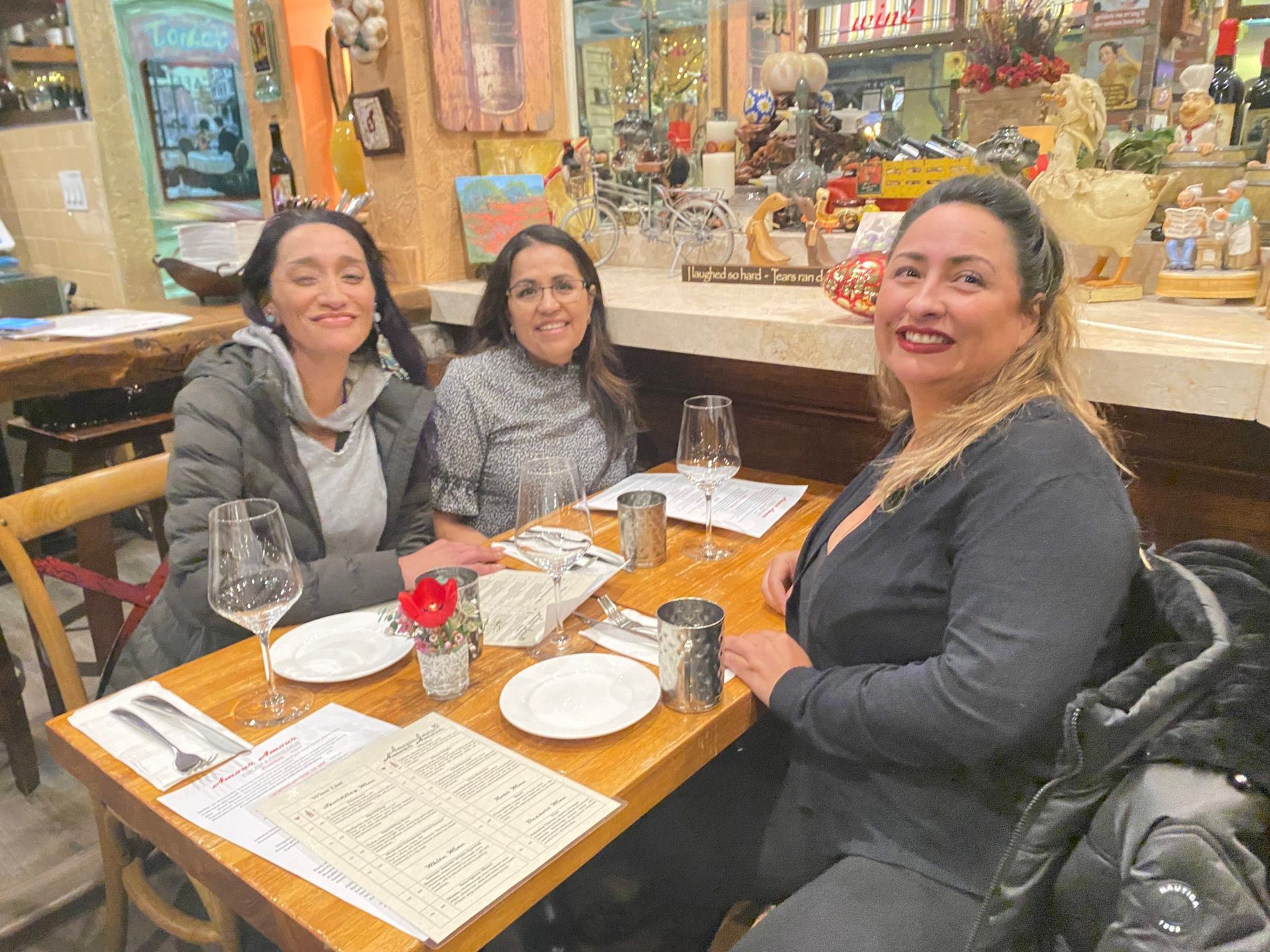Three women are sitting at a table in a restaurant.