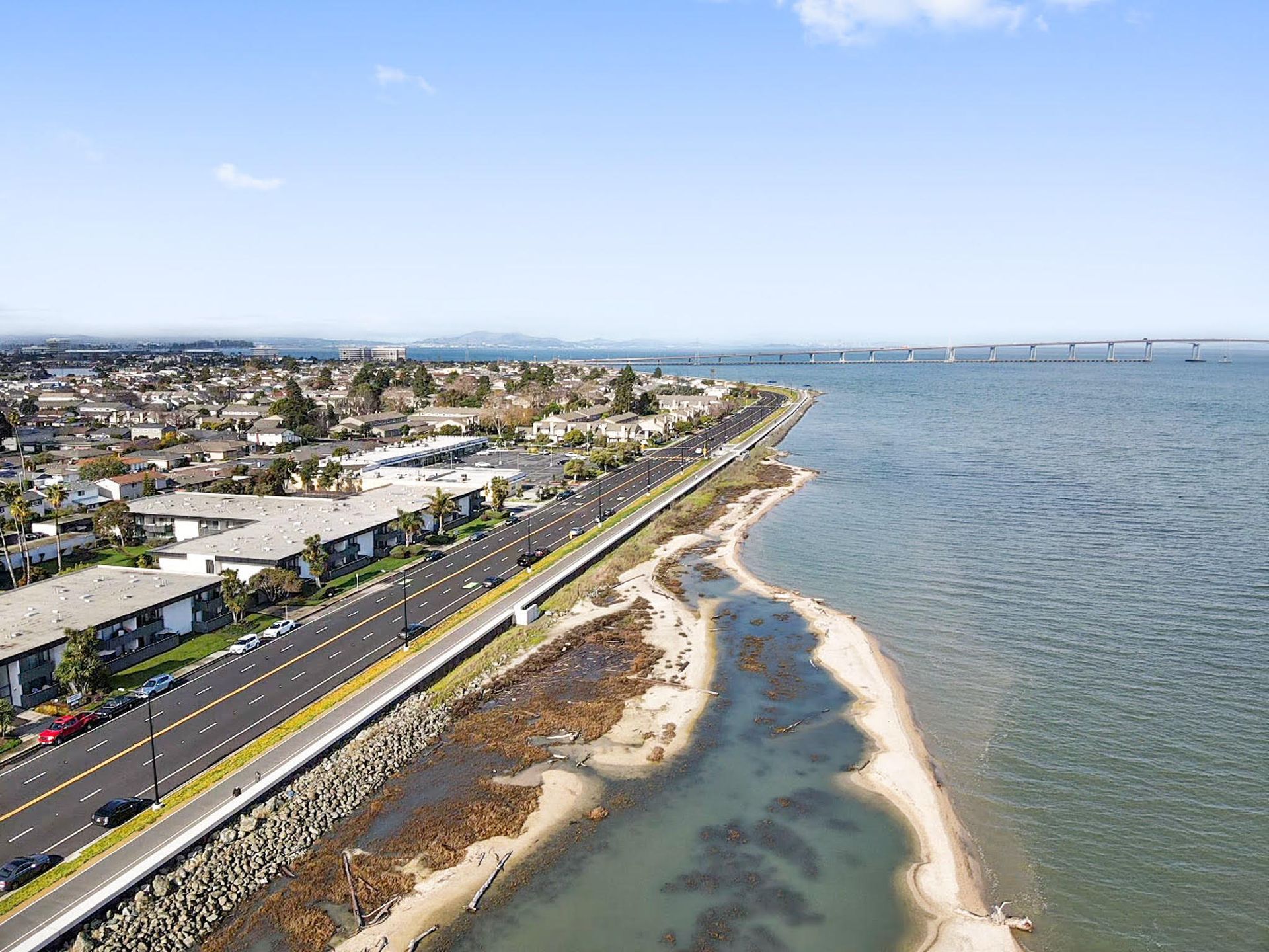 An aerial view of a road next to a body of water.