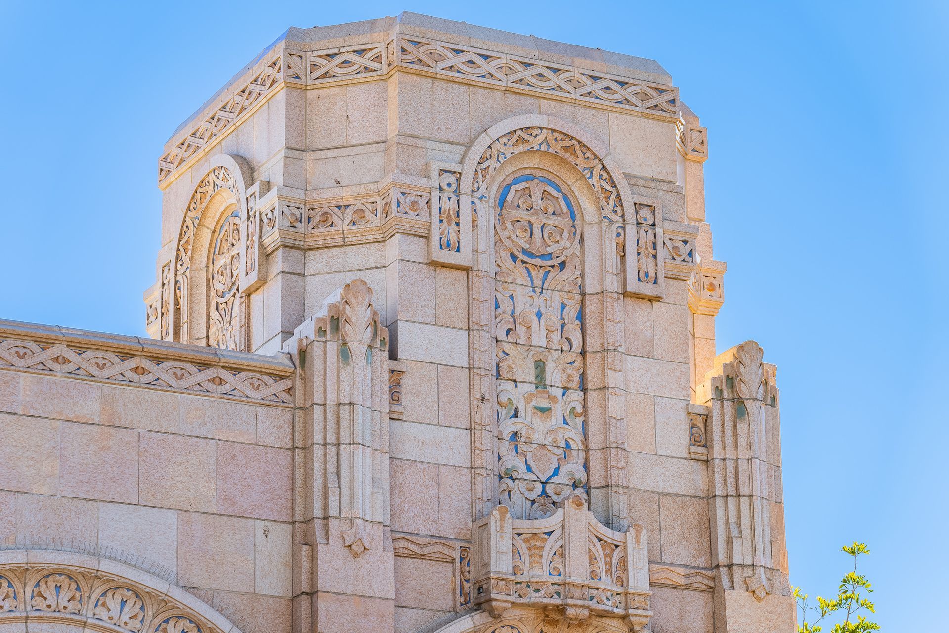 A large stone building with a blue sky in the background.
