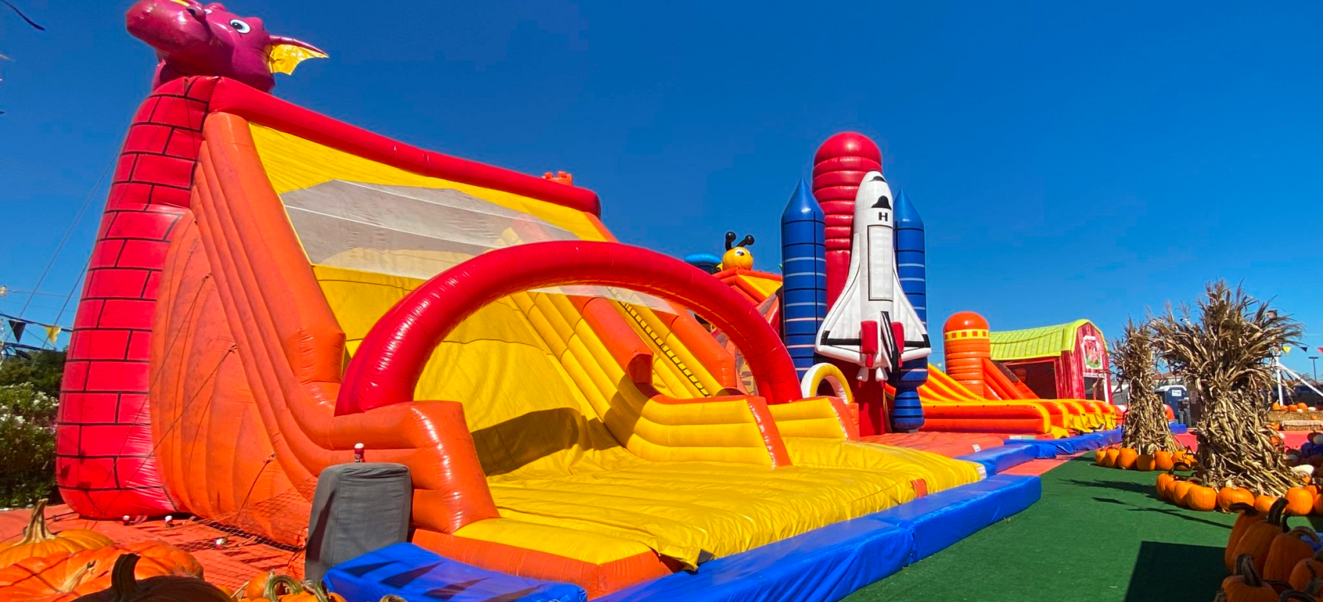 A bunch of inflatable toys are sitting on top of a grass covered field.